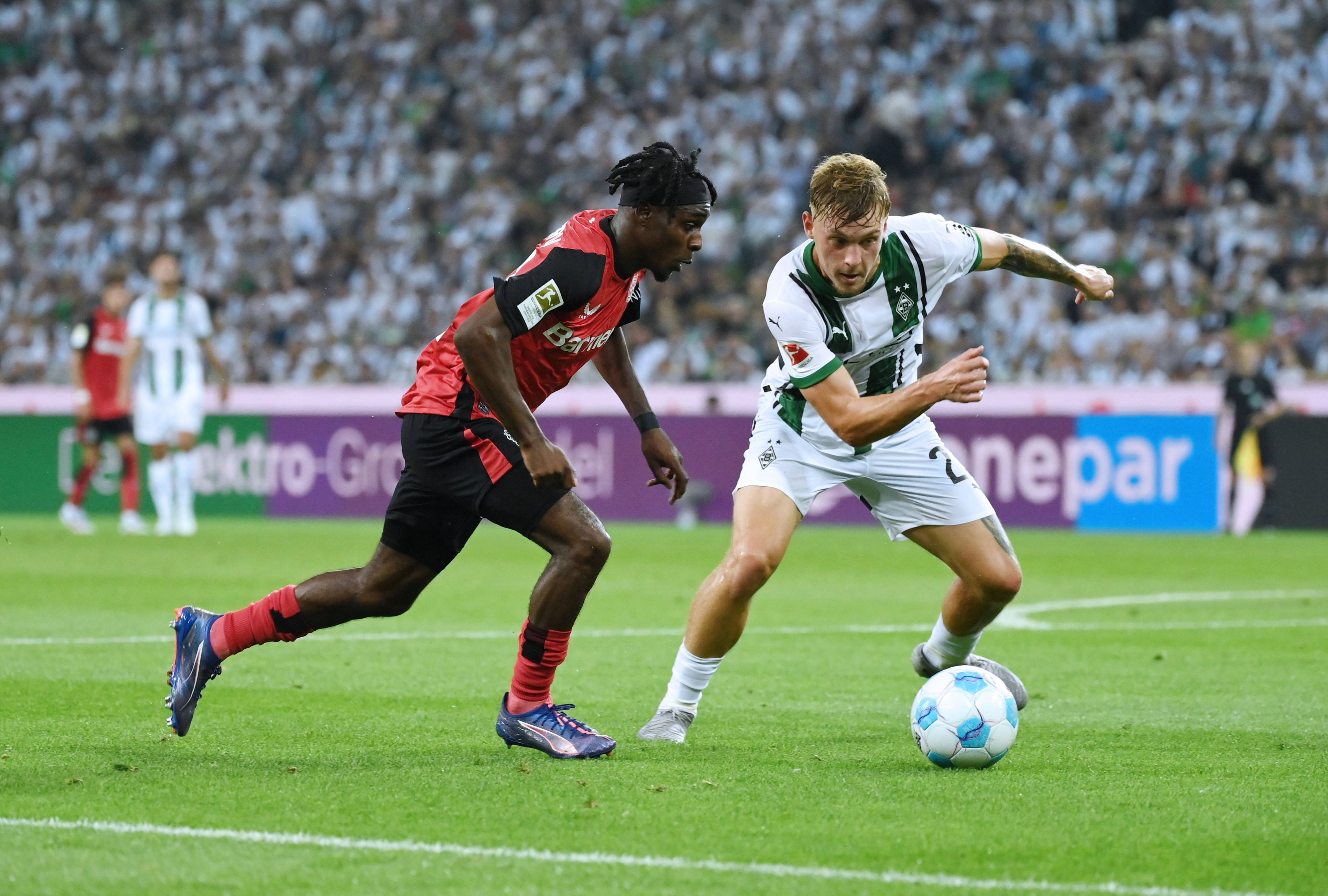Bayer Leverkusens Jeremie Frimpong geht im Zeikampf an Borussia Mönchengladbachs Luca Netz vorbei.