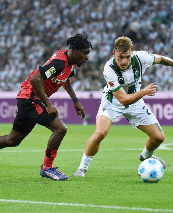 Bayer Leverkusens Jeremie Frimpong geht im Zeikampf an Borussia Mönchengladbachs Luca Netz vorbei.