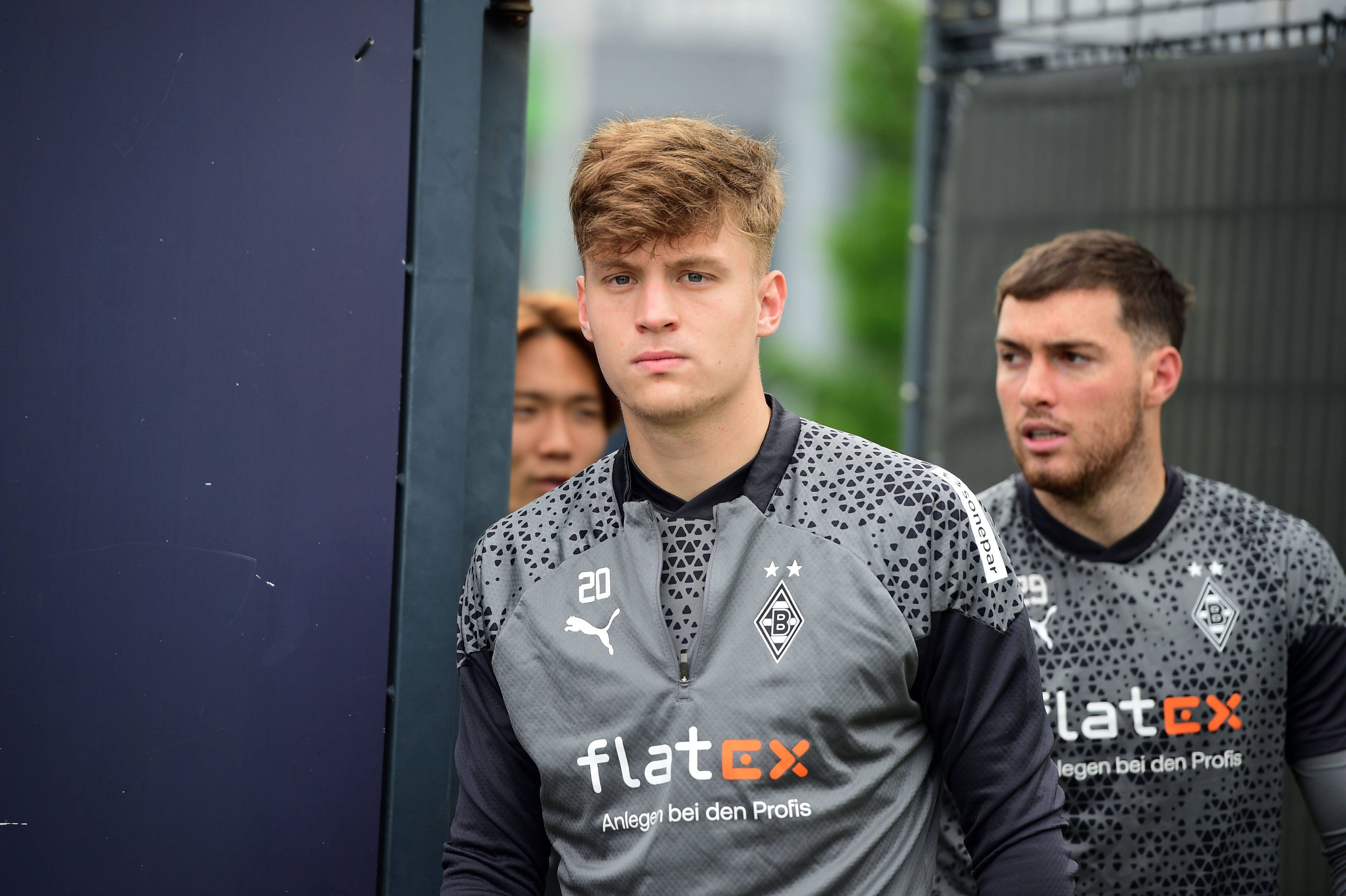 Die Gladbach-Profis Luca Netz, Joe Scally und Ko Itakura laufen hintereinander auf den Trainingsplatz.