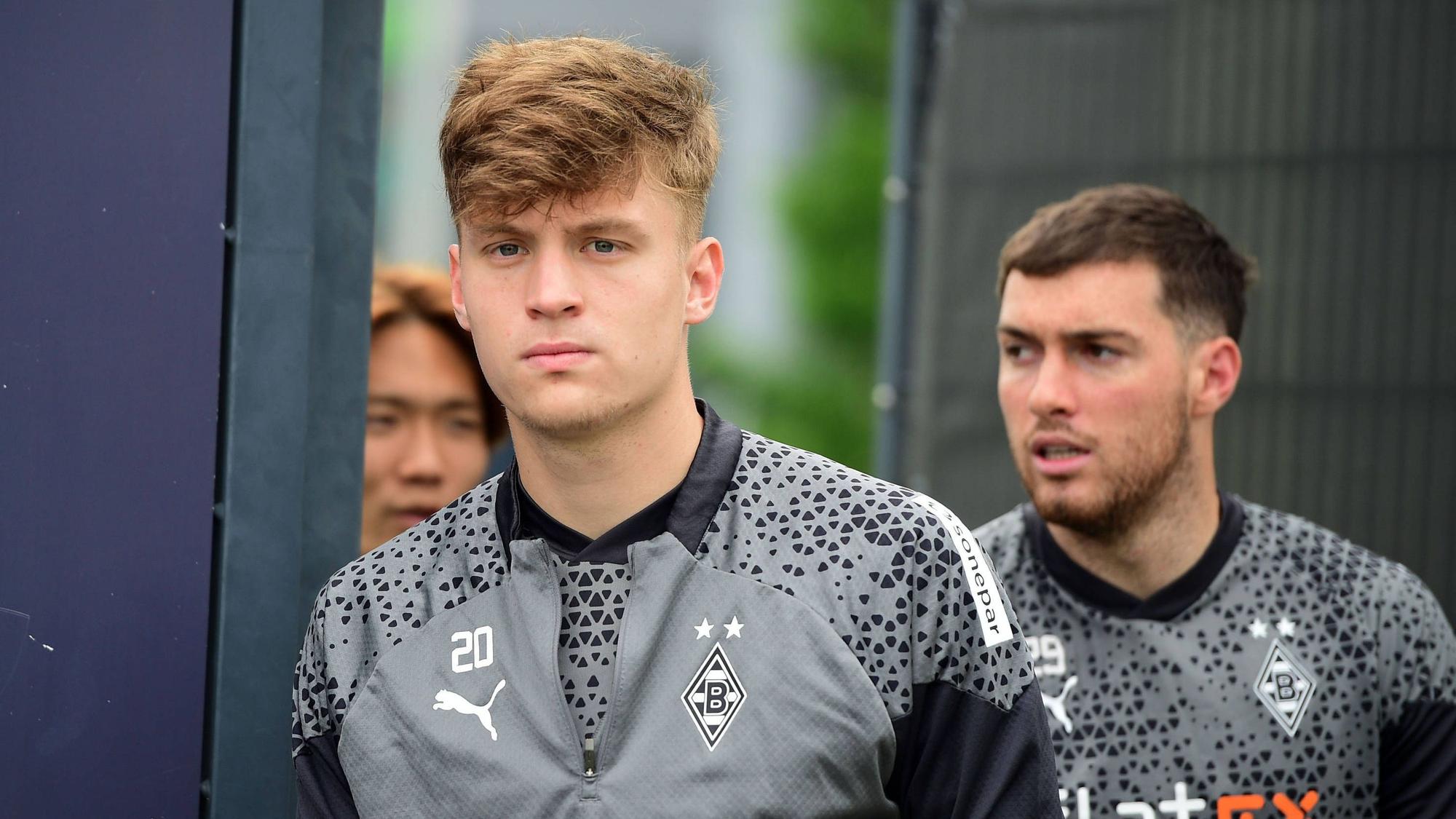 Die Gladbach-Profis Luca Netz, Joe Scally und Ko Itakura laufen hintereinander auf den Trainingsplatz.