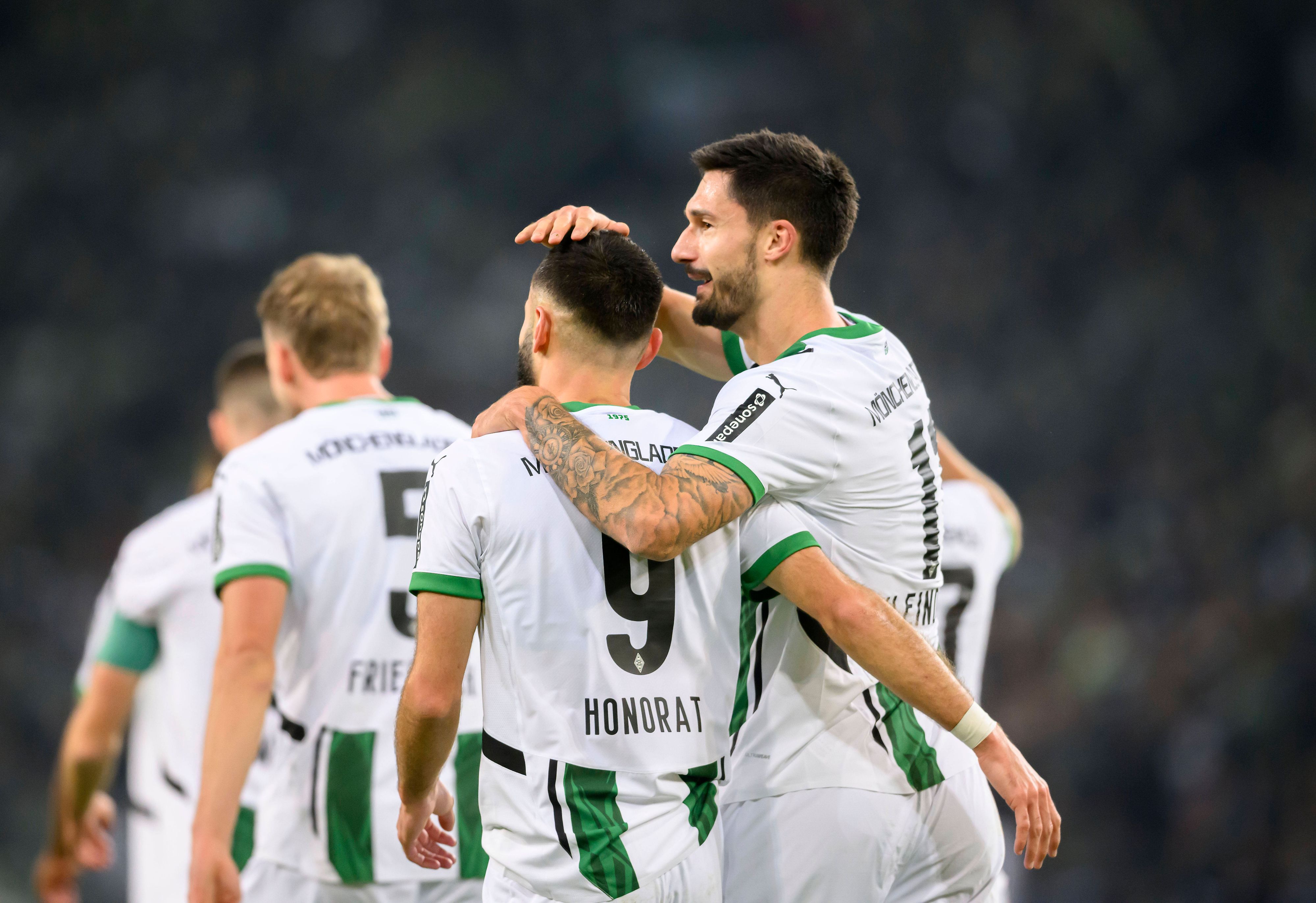 Die Gladbach-Profis Tim Kleindienst und Franck Honorat stehen im Bundesliga-Spiel gegen Werder Bremen Arm in Arm auf dem Platz.