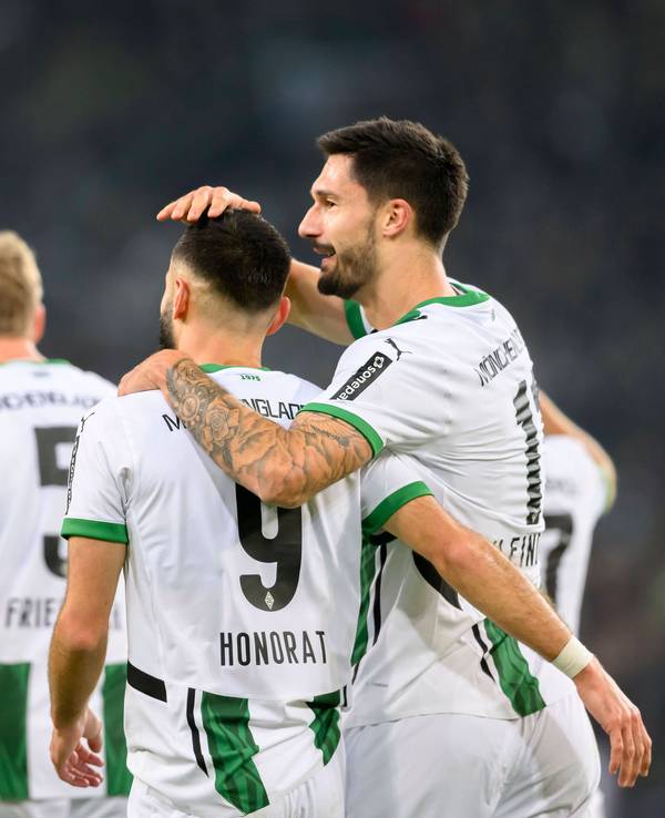 Die Gladbach-Profis Tim Kleindienst und Franck Honorat stehen im Bundesliga-Spiel gegen Werder Bremen Arm in Arm auf dem Platz.