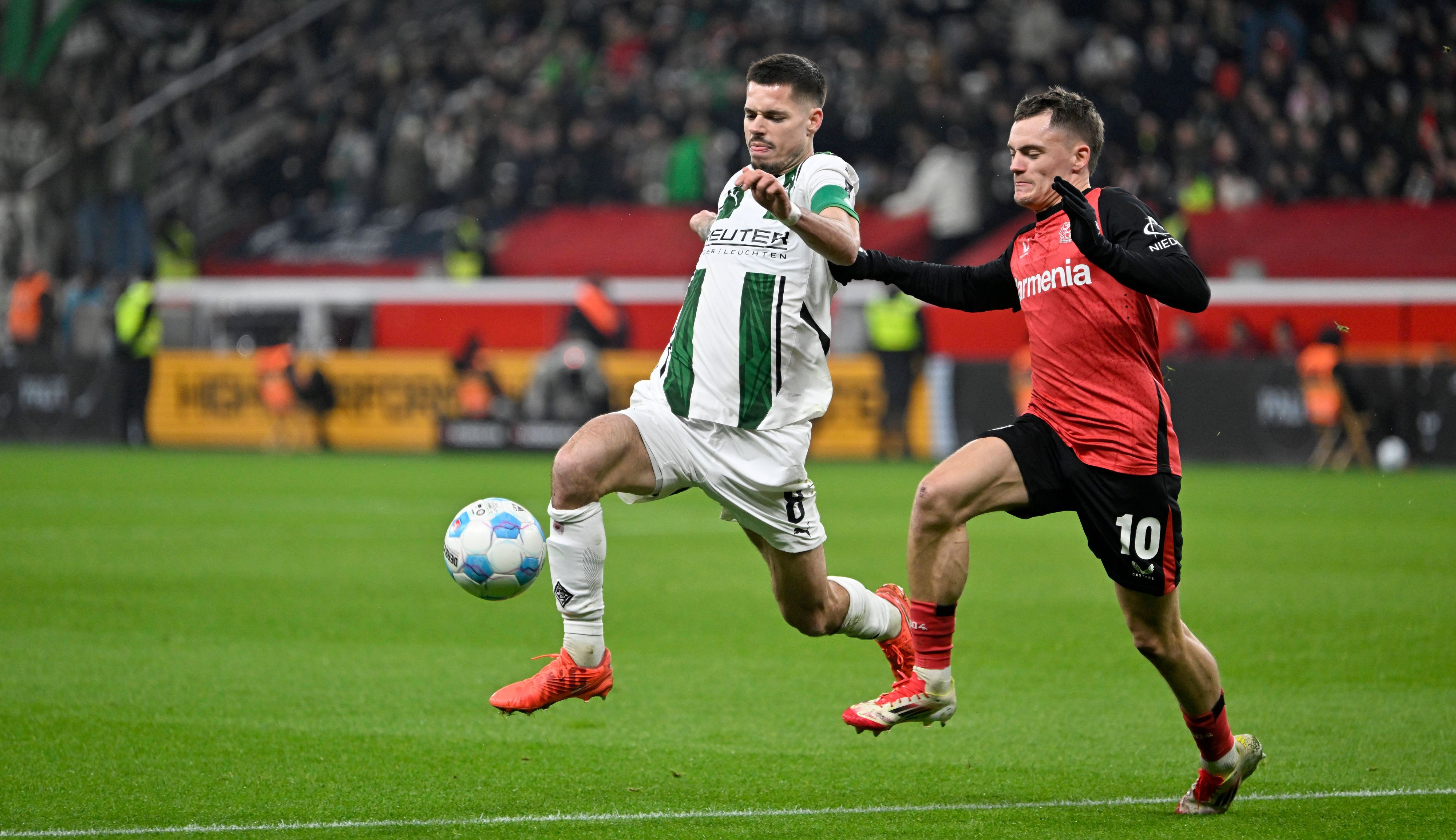 Bayer Leverkusens Florian Wirtz und Borussia Mönchengladbachs Julian Weigl kämpfen um den Ball.