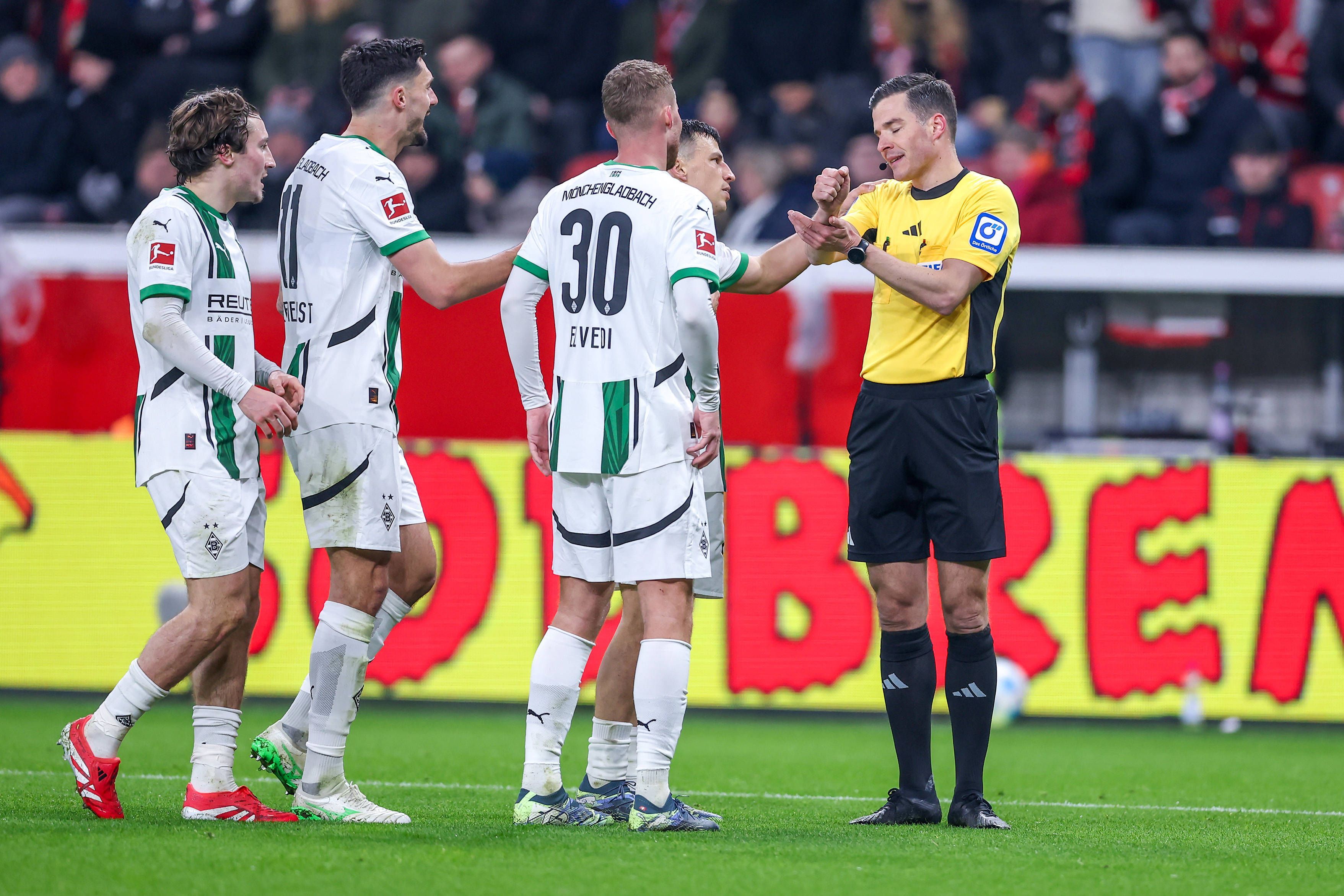 Spieler von Borussia Mönchengladbach beschweren sich beim Schiedsrichter.