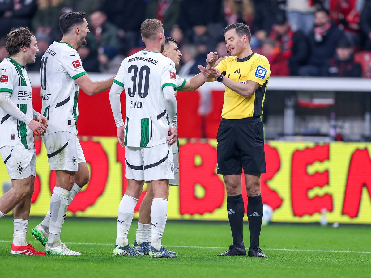Spieler von Borussia Mönchengladbach beschweren sich beim Schiedsrichter.