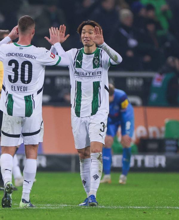 Die Borussia-Profis Ko Itakura und Nico Elvedi klatschen sich im Bundesliga-Spiel gegen Holstein Kiel ab.