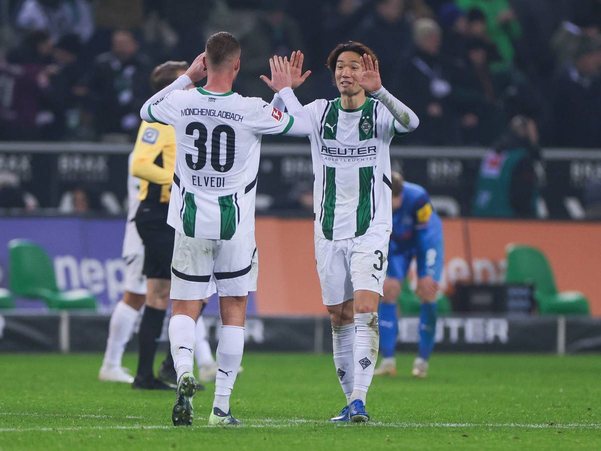 Die Borussia-Profis Ko Itakura und Nico Elvedi klatschen sich im Bundesliga-Spiel gegen Holstein Kiel ab.