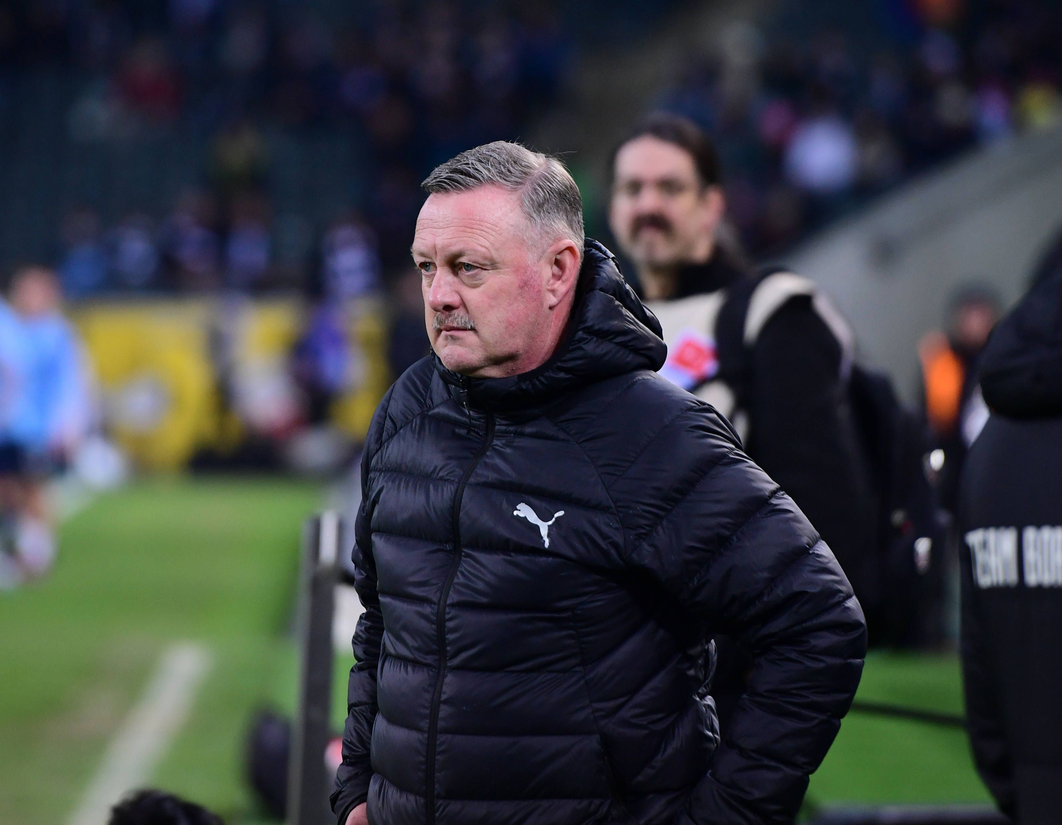 Roland Virkus überlegt am Spielfeldrand.