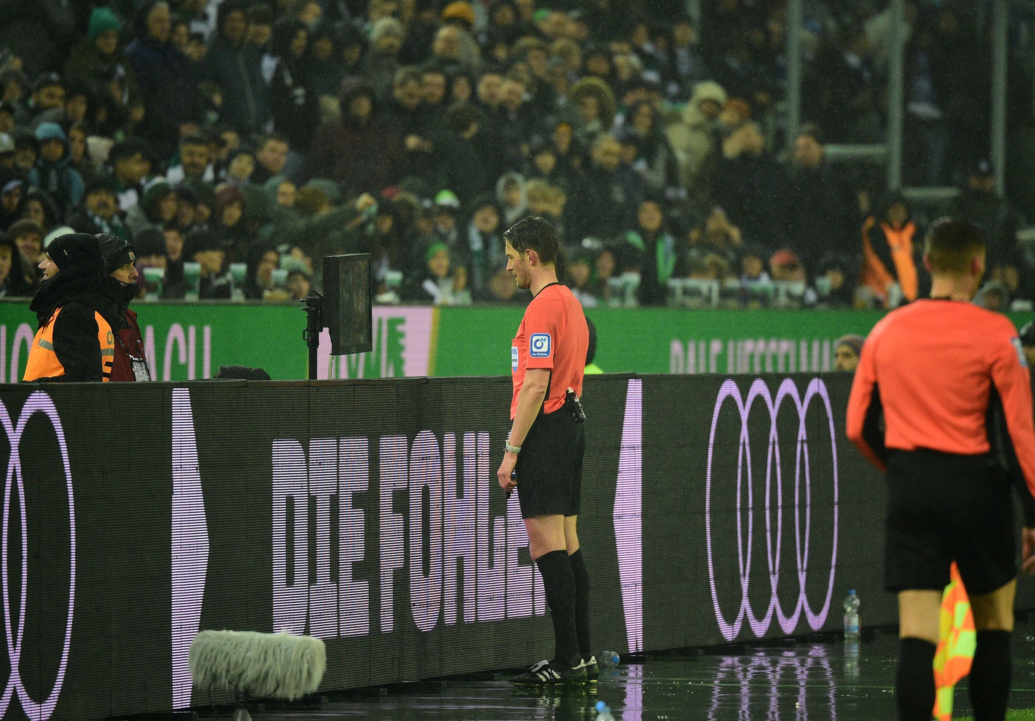 Ein Schiedrsichter steht im Borussia-Park vor dem VAR-Bildschirm.