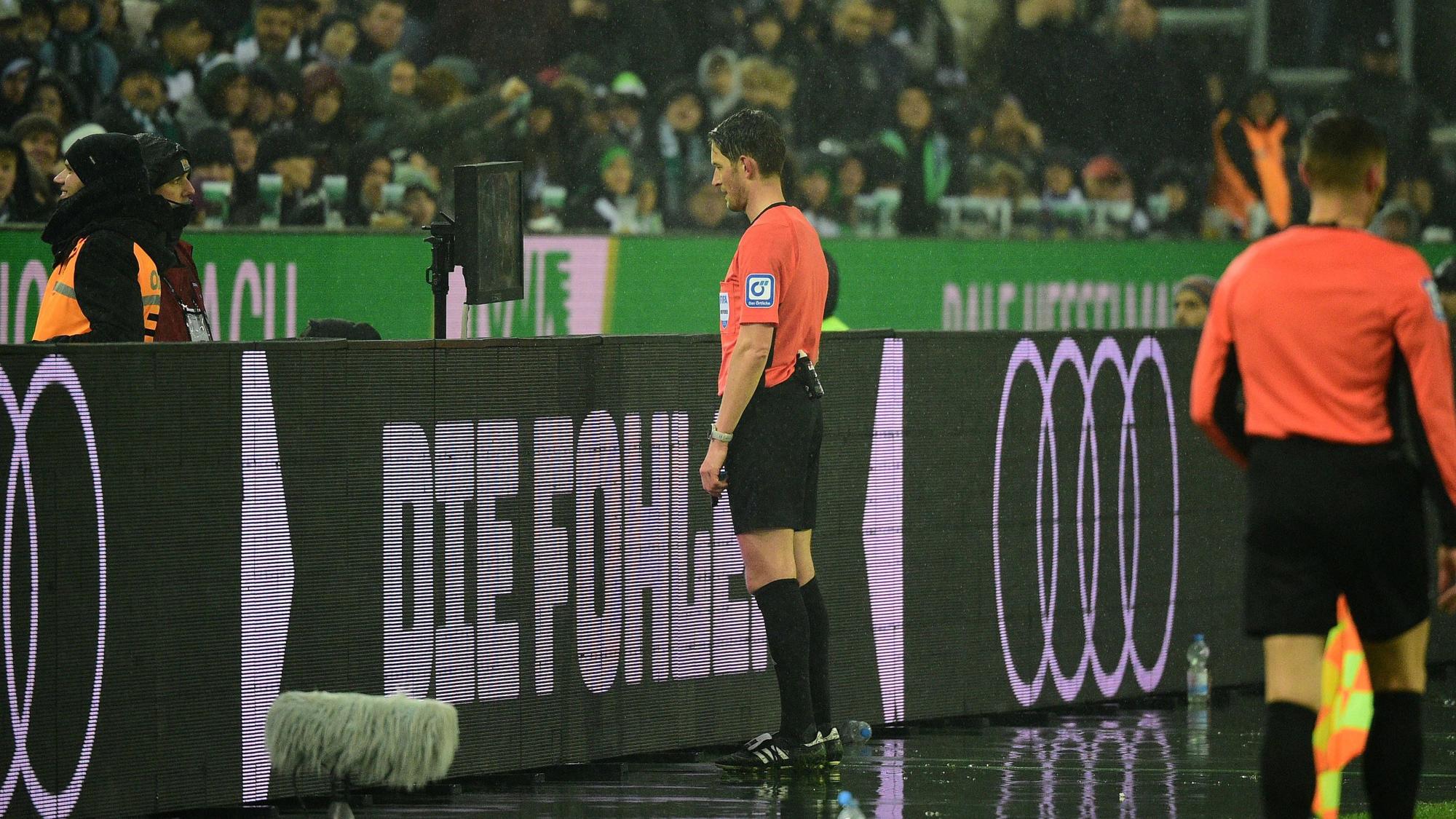 Ein Schiedrsichter steht im Borussia-Park vor dem VAR-Bildschirm.