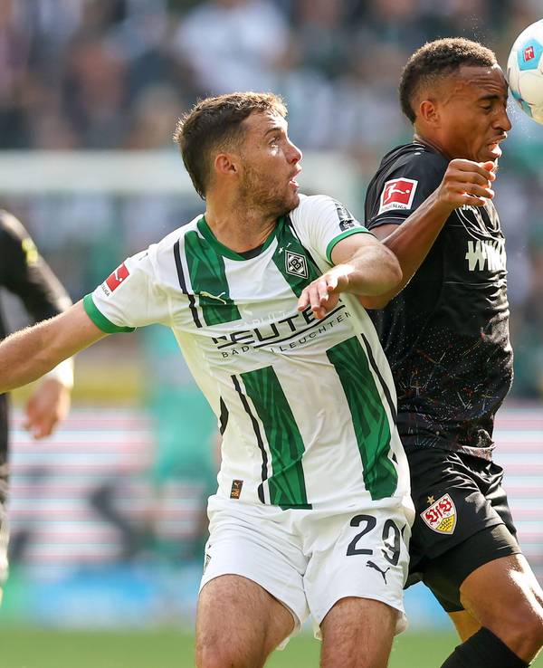 Borussia Mönchengladbachs Joe Scally kämpft im Kopfball-Duell mit Stuttgarts Jamie Leweling um den Ball.