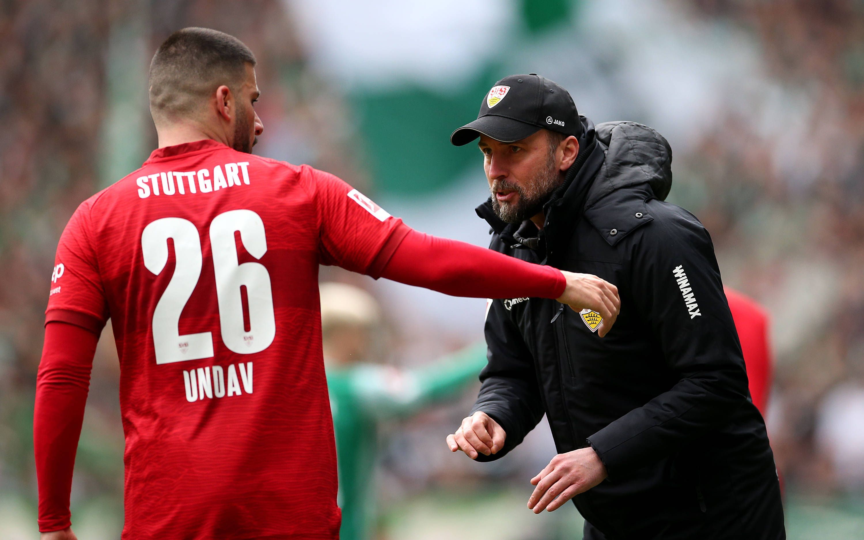 Stuttgarts Trainer Sebastian Hoeneß spricht an der Seitenlinie mit seinem Stürmer Deniz Undav.