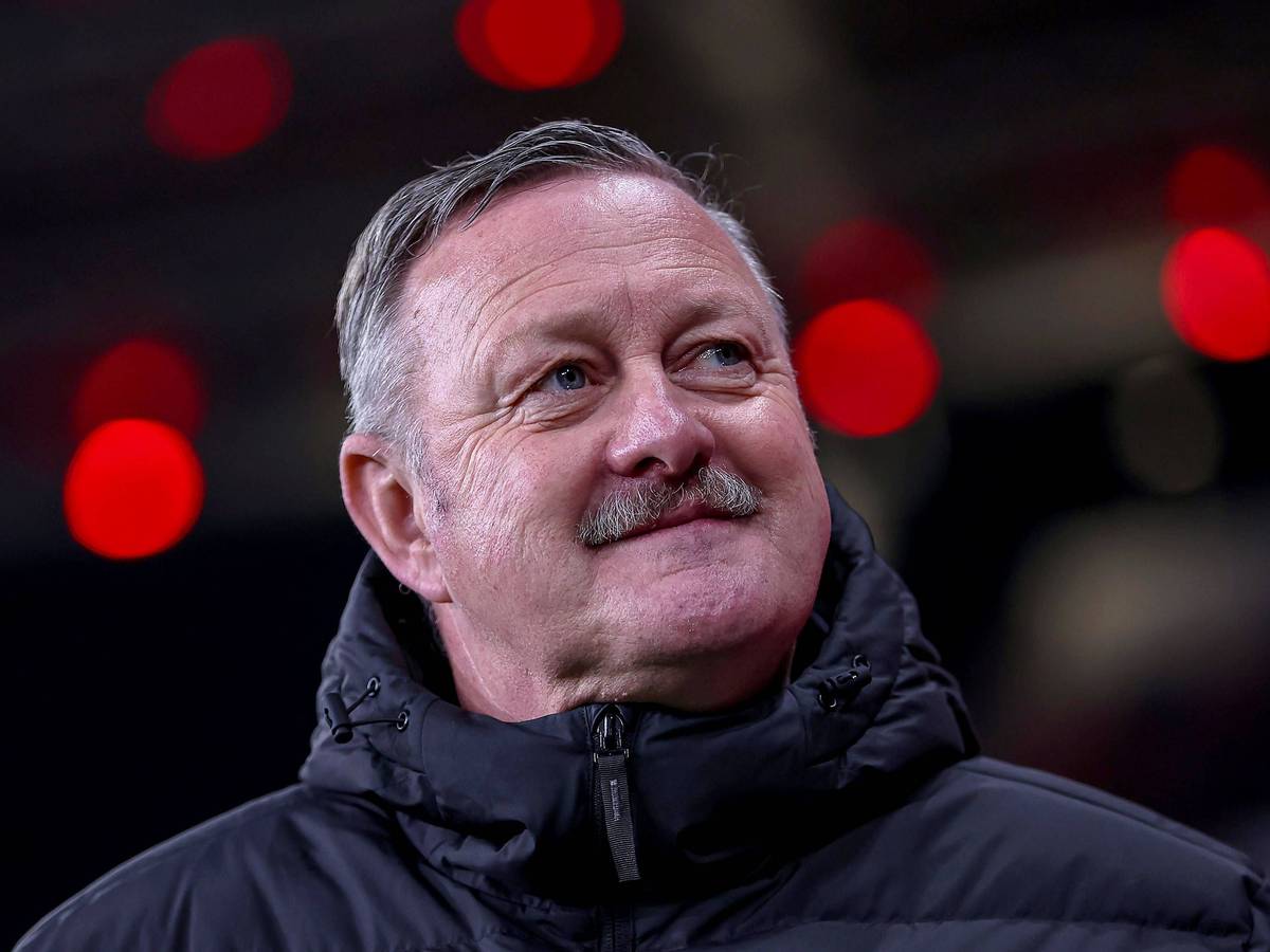 Borussia Mönchengladbachs Sport-Geschäftsführer Roland Virkus steht beim Spiel in Leverkusen im Stadion und lächelt.