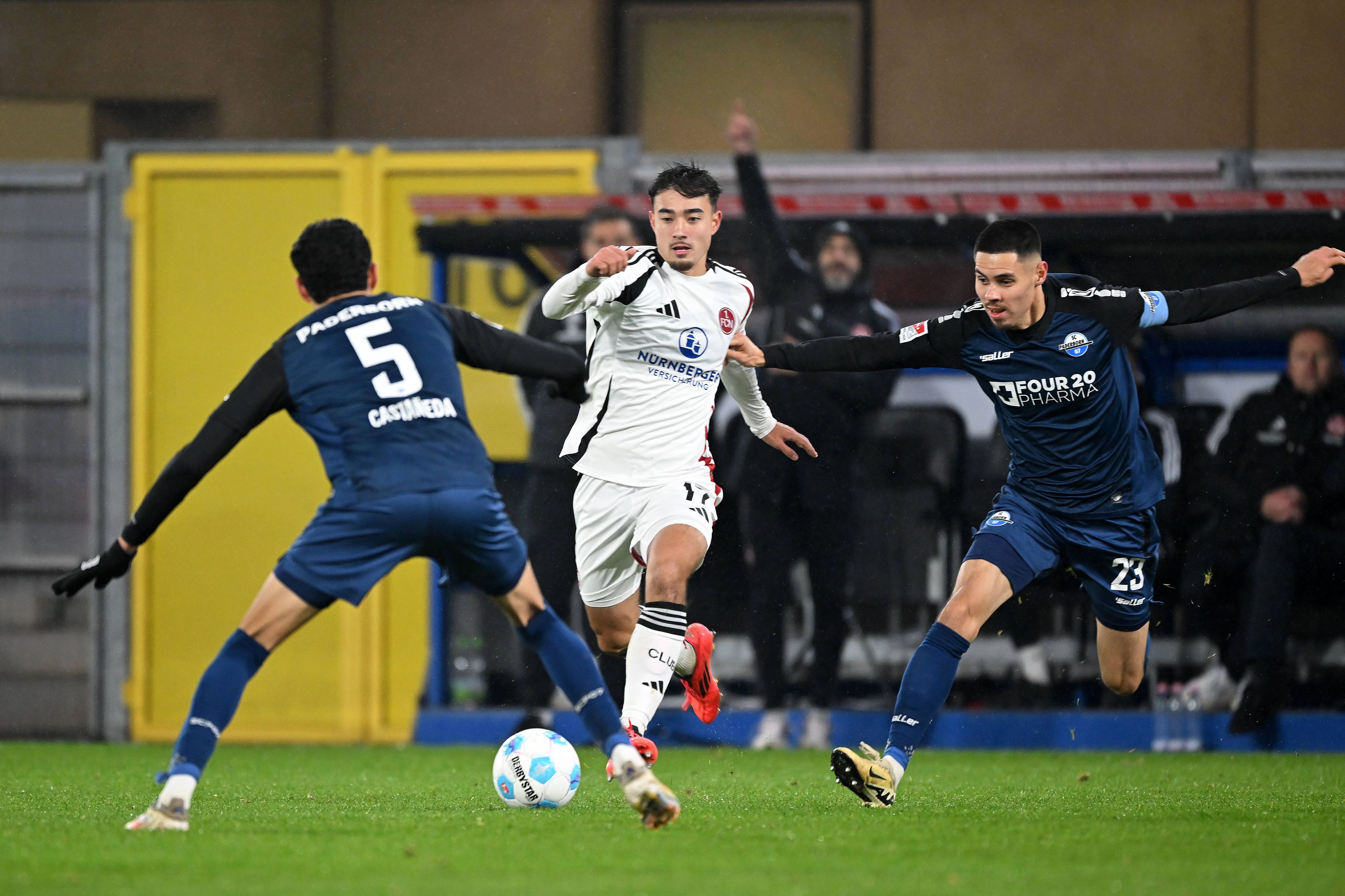 Jens Castrop vom 1. FC Nürnberg führt den Ball im Spiel beim SC Paderborn, Santiago Castaneda und Raphael Obermair versuchen, ihn zu stoppen.