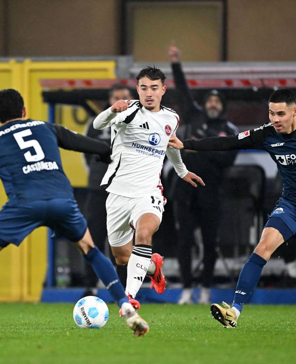 Jens Castrop vom 1. FC Nürnberg führt den Ball im Spiel beim SC Paderborn, Santiago Castaneda und Raphael Obermair versuchen, ihn zu stoppen.