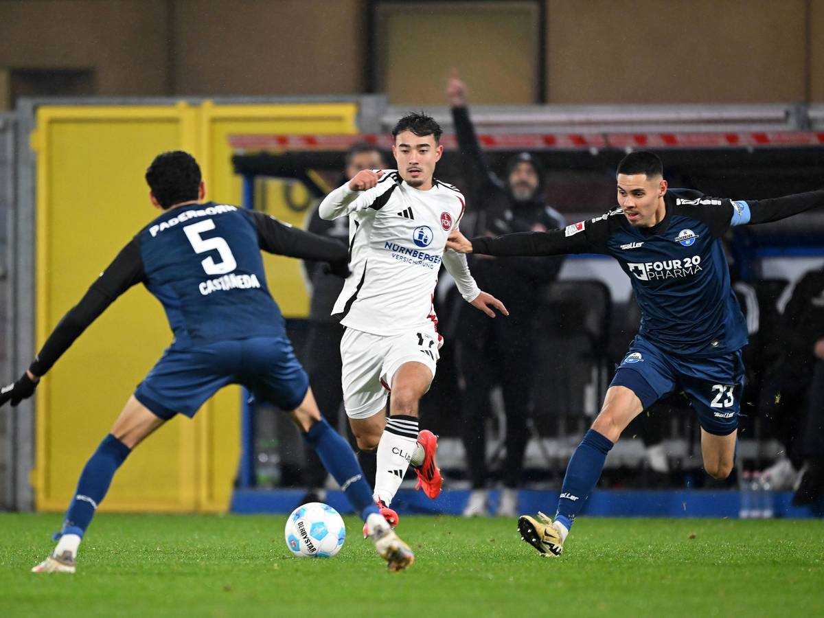 Jens Castrop vom 1. FC Nürnberg führt den Ball im Spiel beim SC Paderborn, Santiago Castaneda und Raphael Obermair versuchen, ihn zu stoppen.