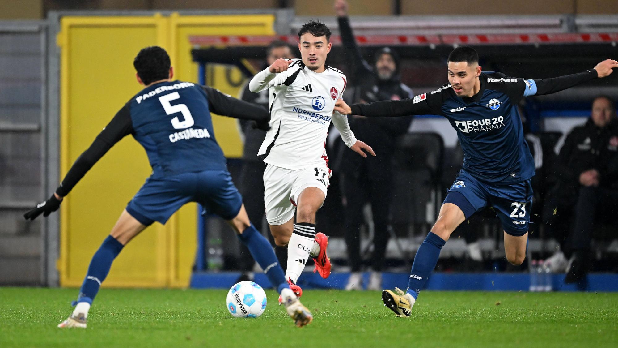 Jens Castrop vom 1. FC Nürnberg führt den Ball im Spiel beim SC Paderborn, Santiago Castaneda und Raphael Obermair versuchen, ihn zu stoppen.