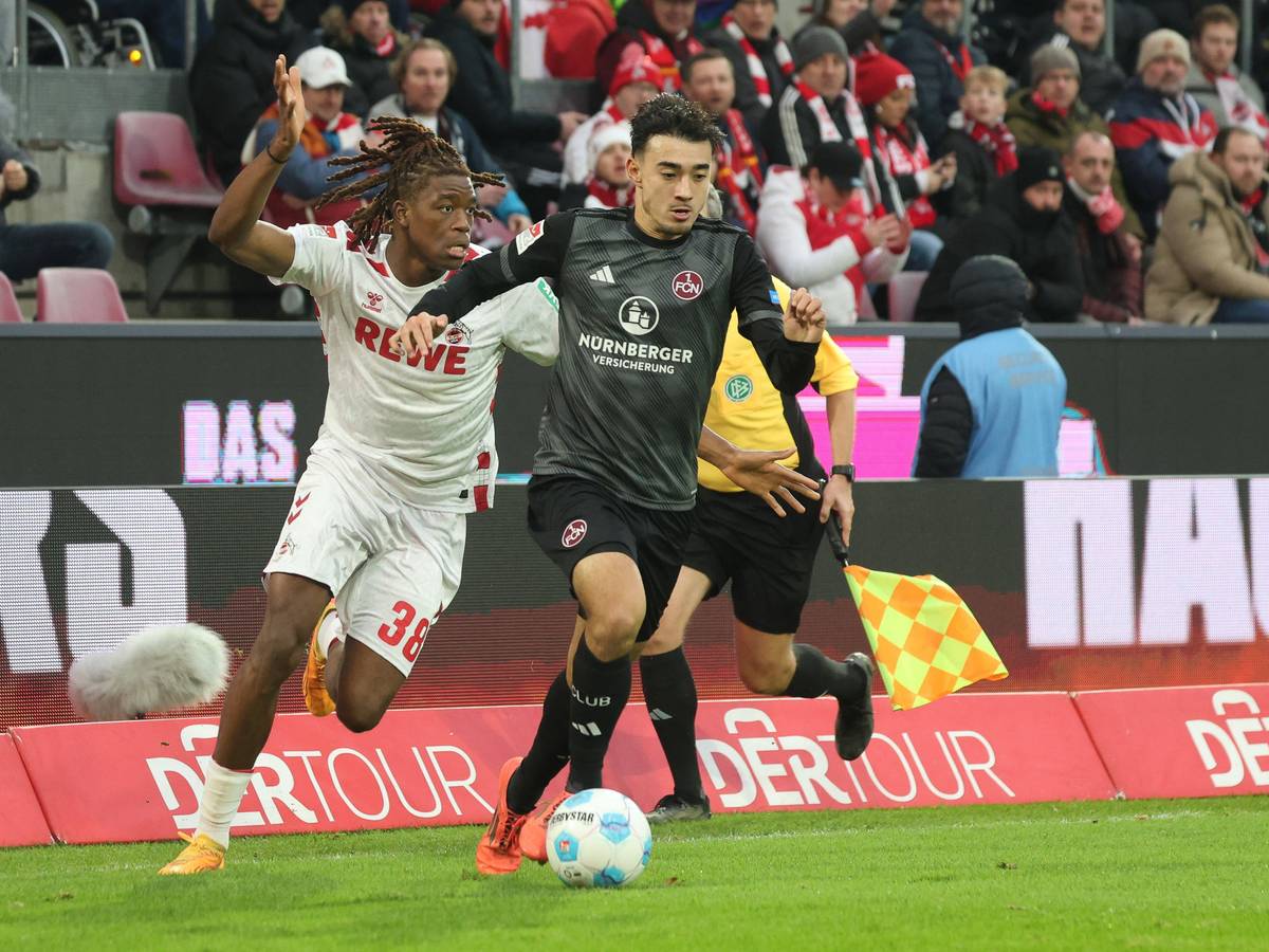 Nürnbergs Jens Castrop führt den Ball, Kölns Elias Bakatukanda verfolgt ihn.
