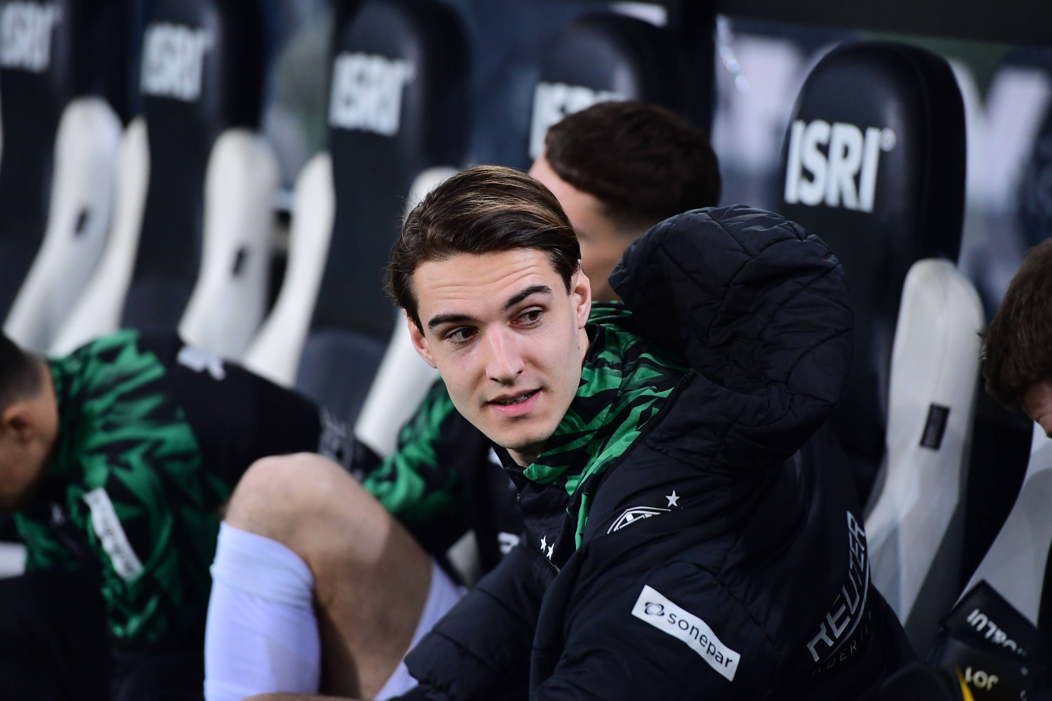 Borussia Mönchengladbachs Florian Neuhaus sitzt beim Bundesliga-Spiel gegen den VfL Bochum auf der Bank und spricht mit einem Teamkollegen.