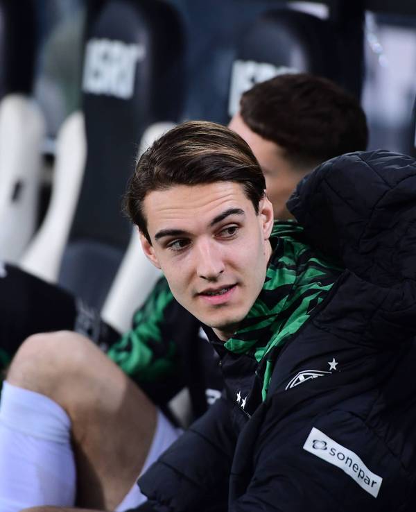 Borussia Mönchengladbachs Florian Neuhaus sitzt beim Bundesliga-Spiel gegen den VfL Bochum auf der Bank und spricht mit einem Teamkollegen.