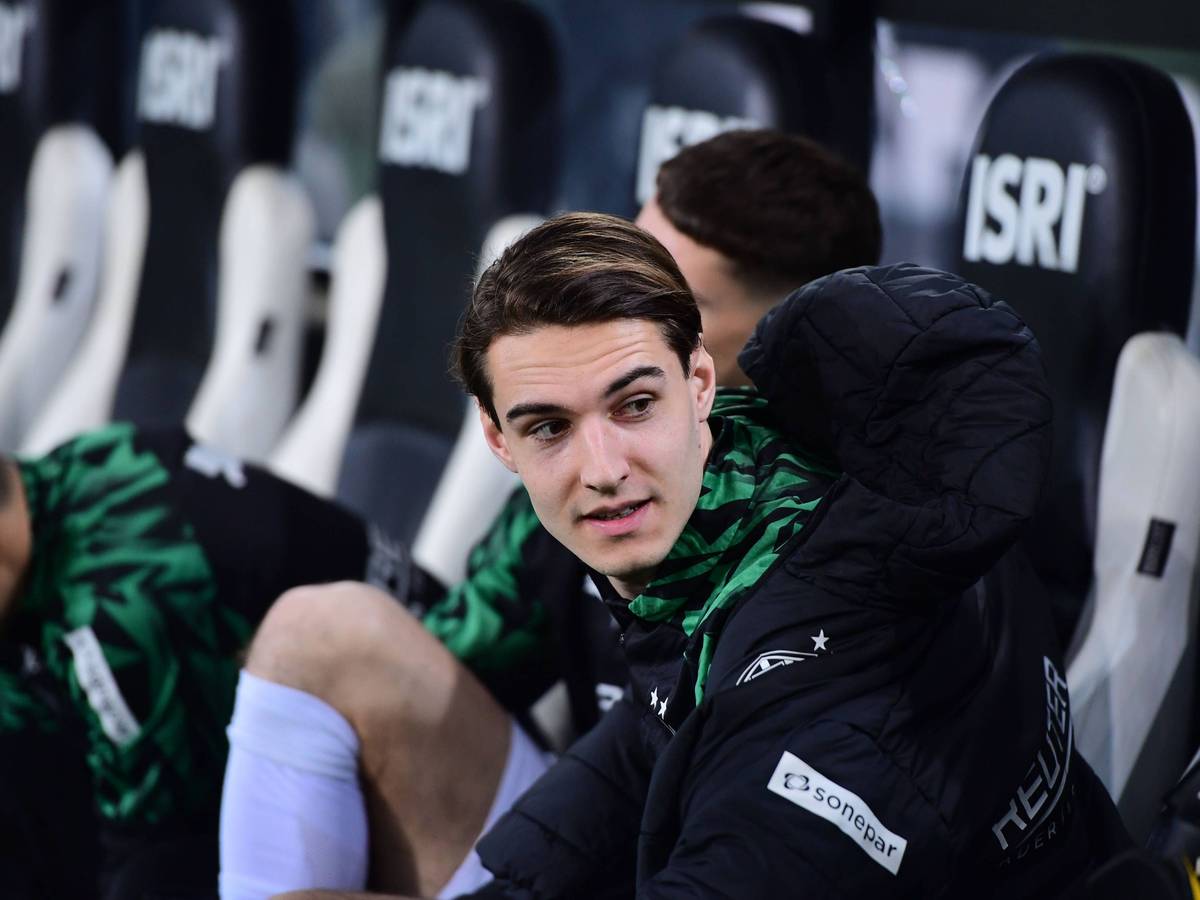 Borussia Mönchengladbachs Florian Neuhaus sitzt beim Bundesliga-Spiel gegen den VfL Bochum auf der Bank und spricht mit einem Teamkollegen.