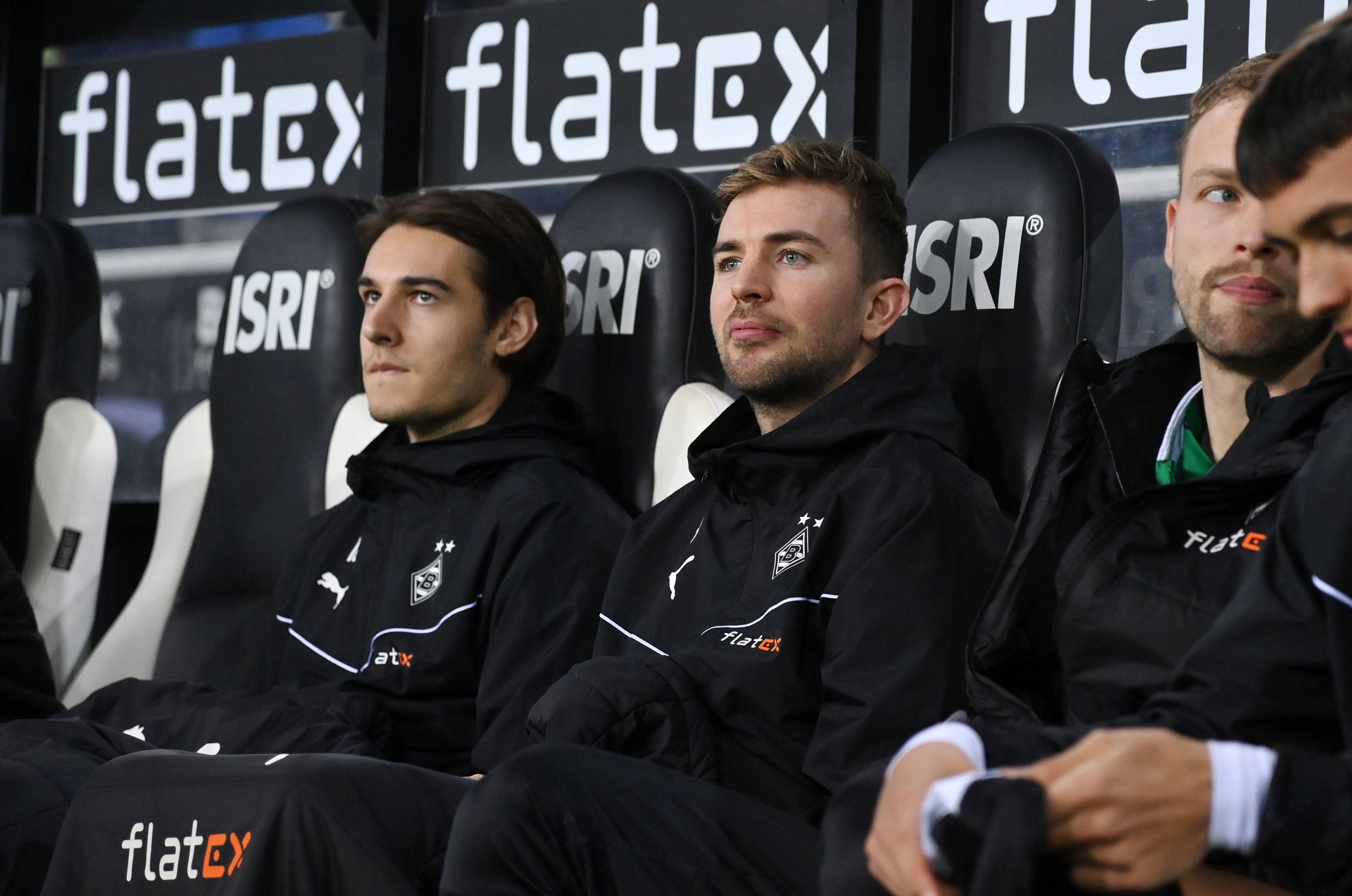 Christoph Kramer und Flo Neuhaus sitzen auf der Gladbach-Bank in Winterjacken und Decken.