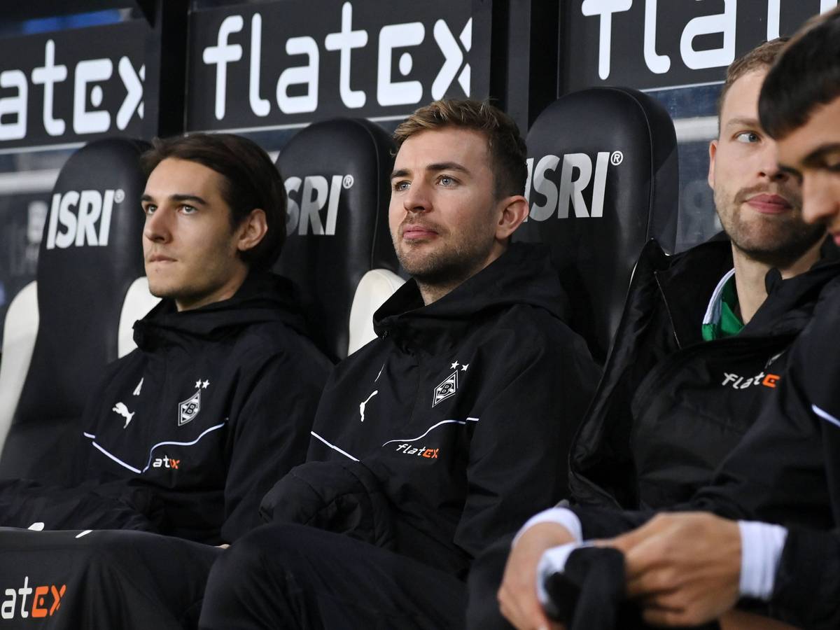Christoph Kramer und Flo Neuhaus sitzen auf der Gladbach-Bank in Winterjacken und Decken.
