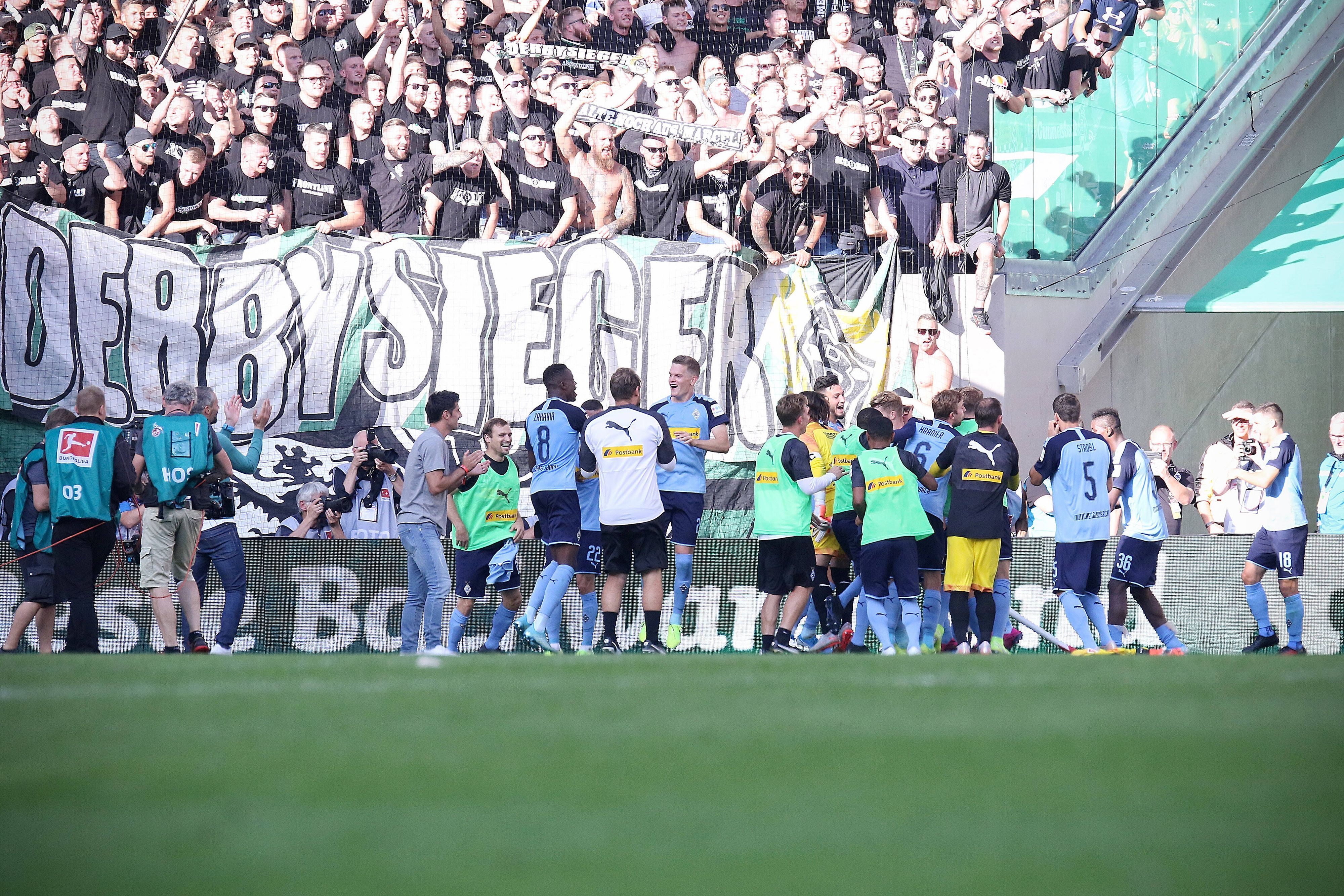 Spieler von Borussia Mönchengladbach feiern einen Derbysieg mit den Fans.