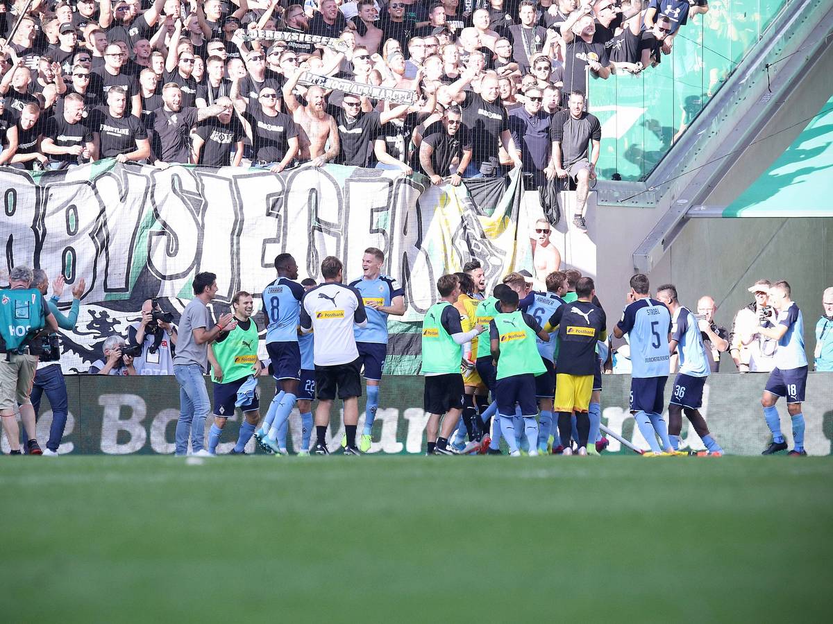 Spieler von Borussia Mönchengladbach feiern einen Derbysieg mit den Fans.