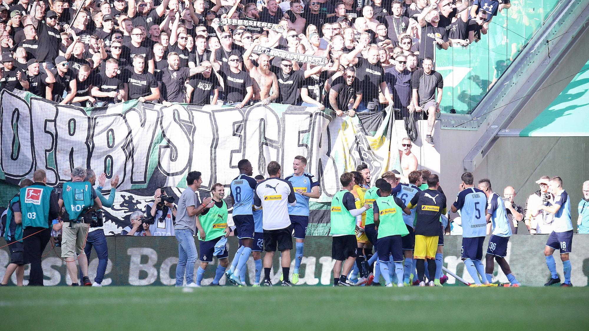Spieler von Borussia Mönchengladbach feiern einen Derbysieg mit den Fans.