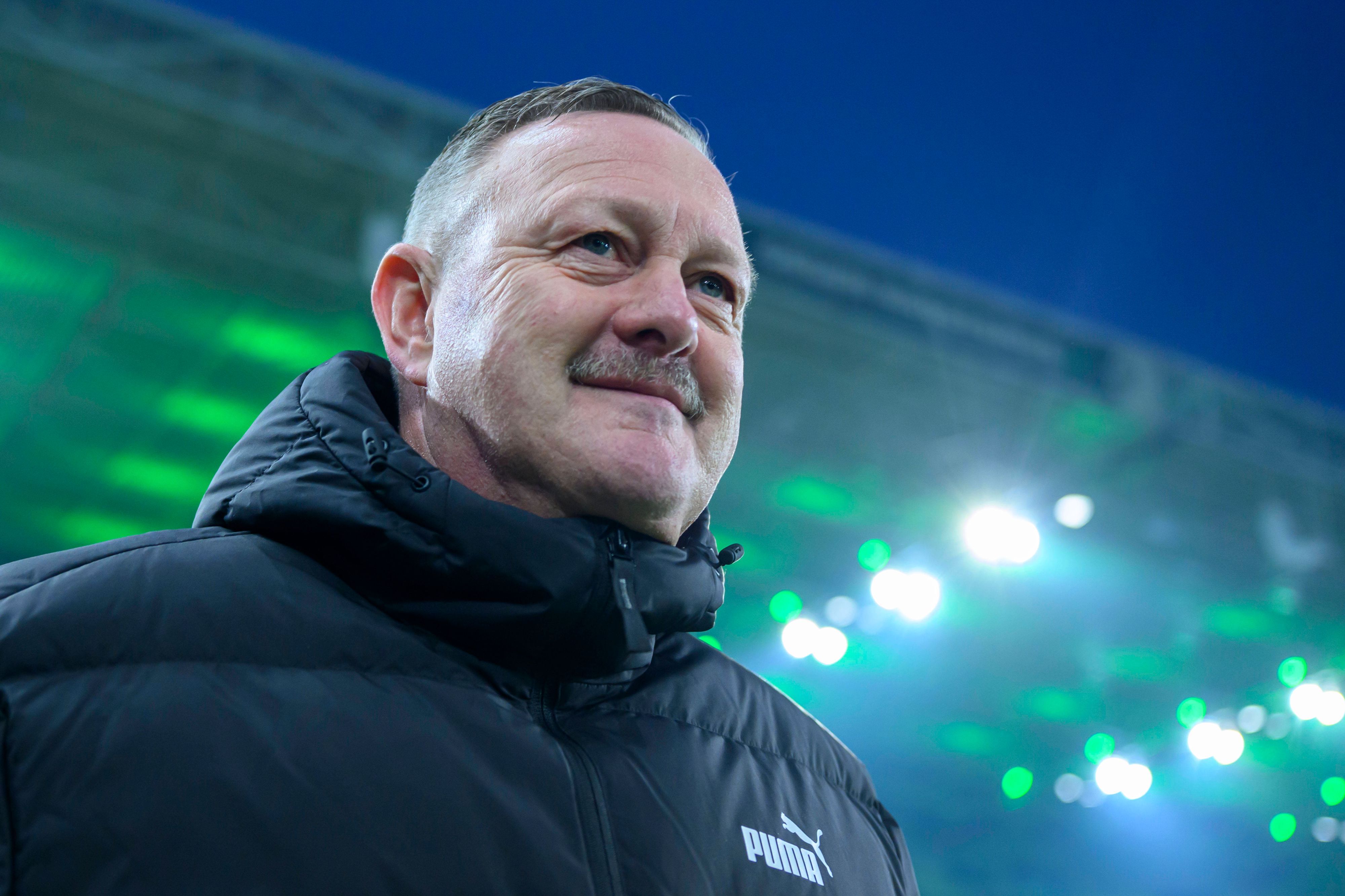 Roland Virkus grinst. Im Hintergrund ist das Dach des Borussia-Parks in grün.