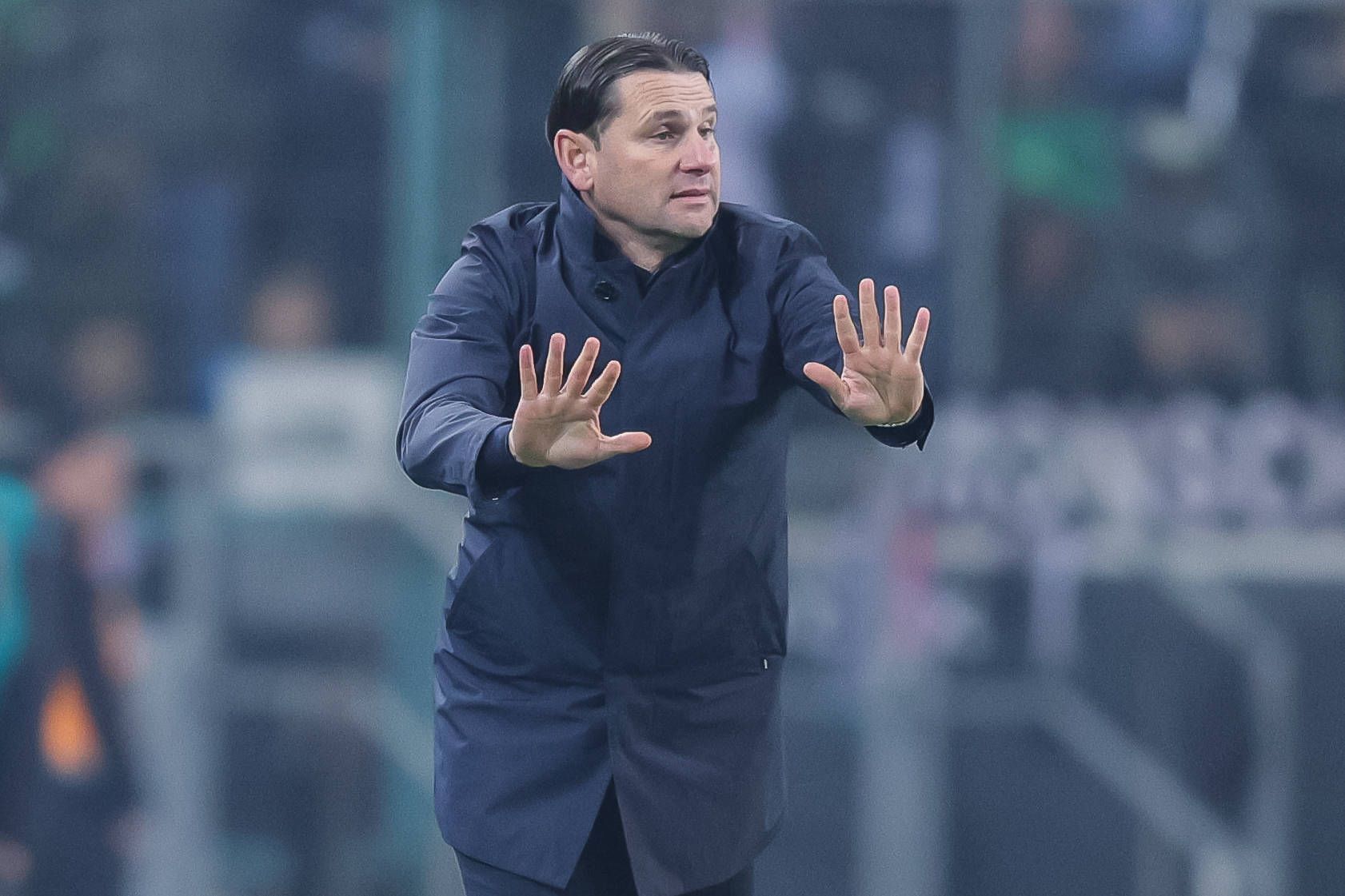 Borussia Mönchengladbachs Trainer Gerardo Seoane steht beim Bundesliga-Spiel gegen Eintracht Frankfurt am Spielfeldrand und mahnt mit beiden Händen zur Ruhe.
