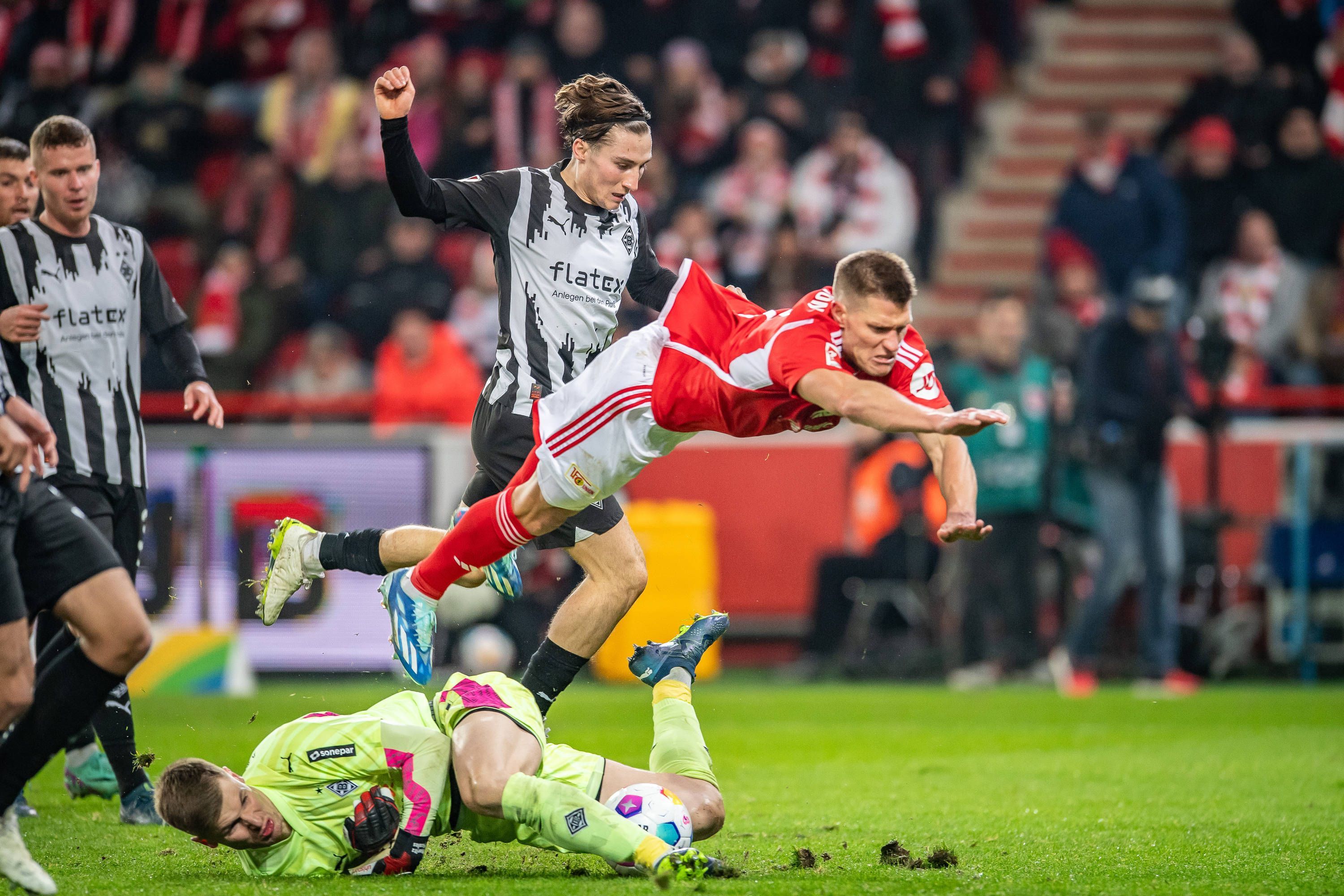 Kevin Behrens hebt ab, Moritz Nicolas kämpft am Boden um den Ball.