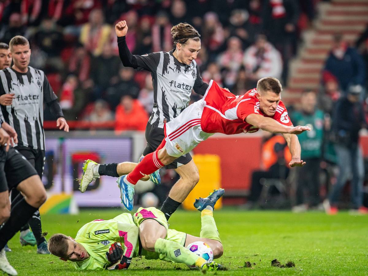 Kevin Behrens hebt ab, Moritz Nicolas kämpft am Boden um den Ball.