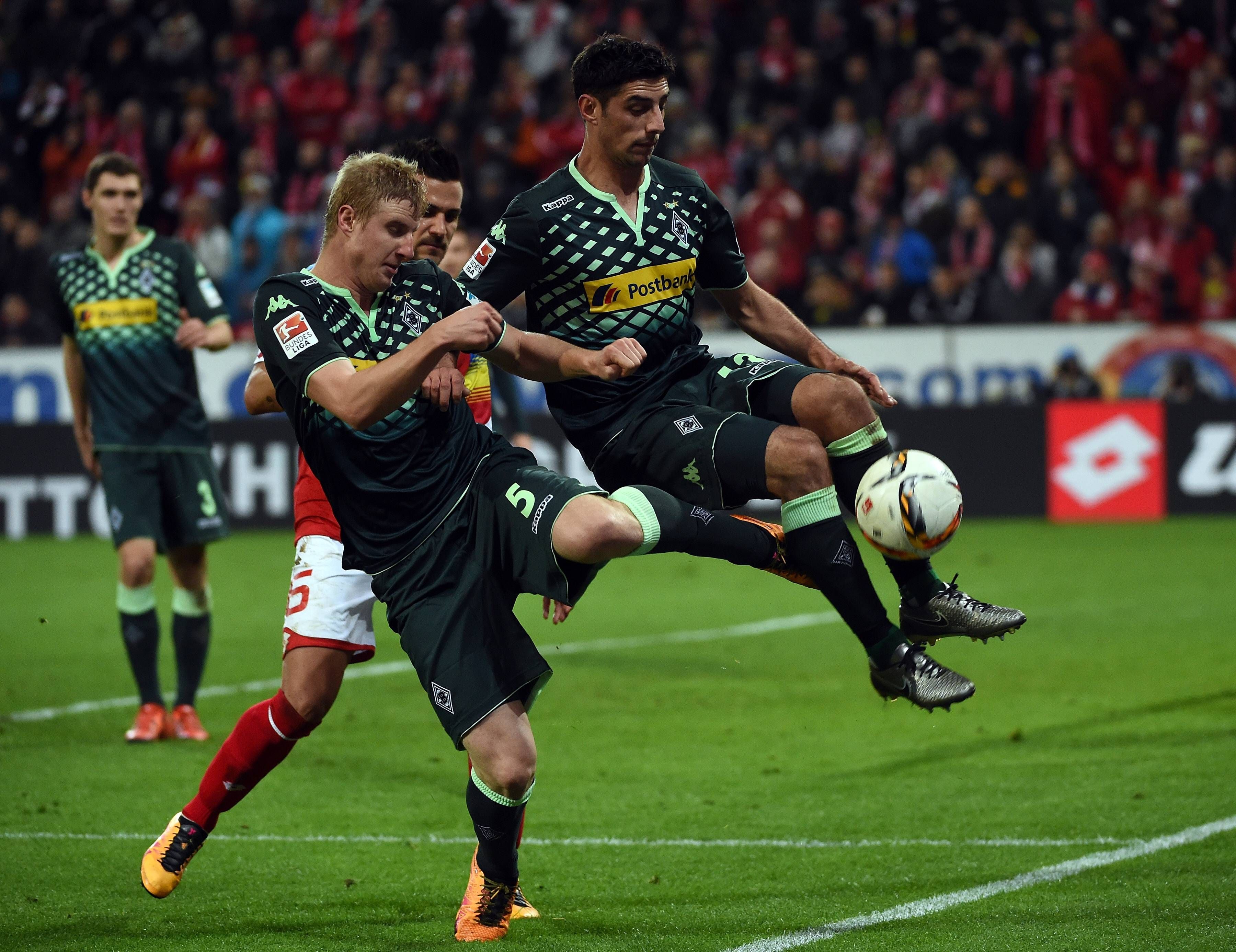 Martin Hinteregger versucht einen Ball zu klären, erwischt dabei aber auch den in der Luft stehenden Lars Stindl von hinten.