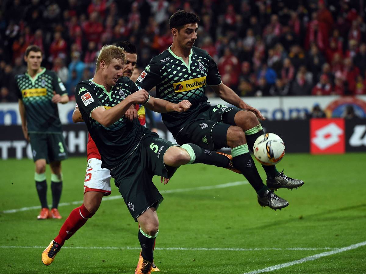 Martin Hinteregger versucht einen Ball zu klären, erwischt dabei aber auch den in der Luft stehenden Lars Stindl von hinten.