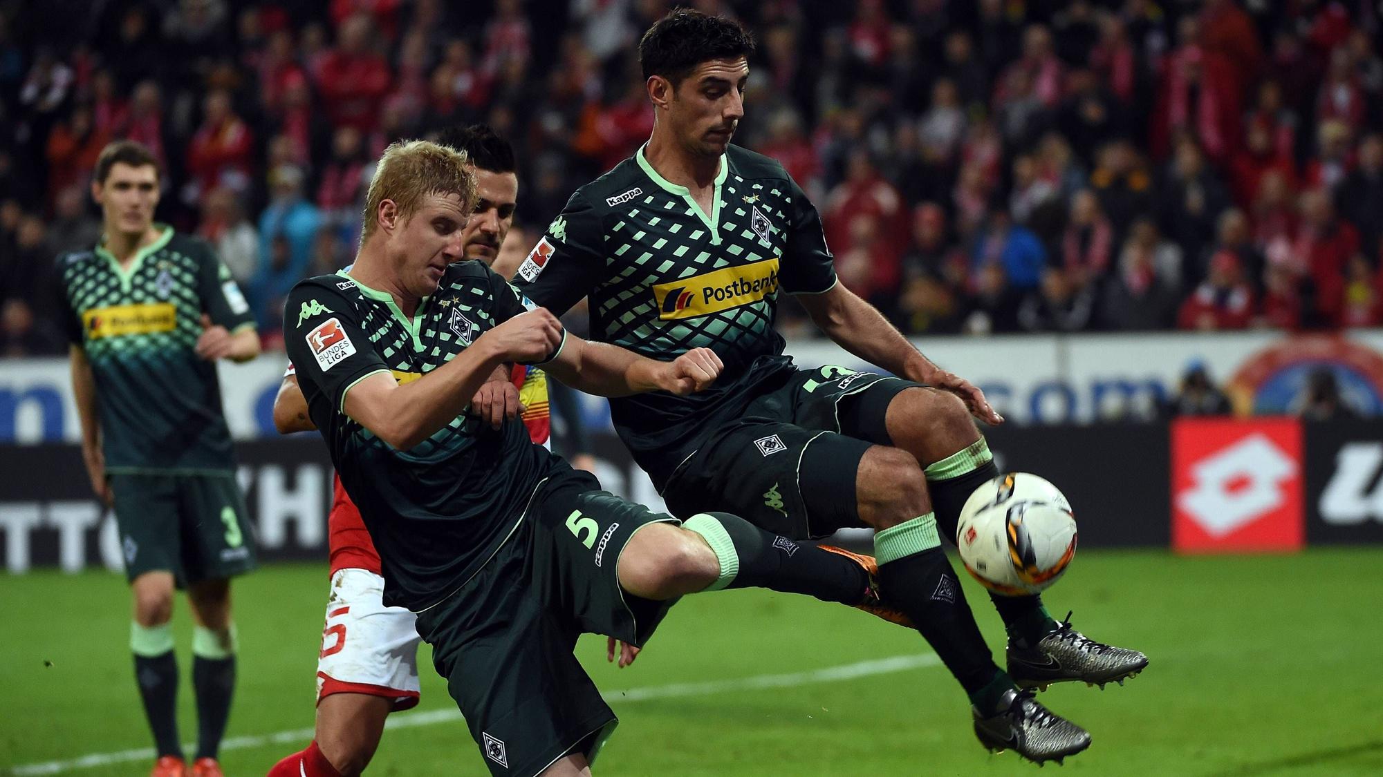 Martin Hinteregger versucht einen Ball zu klären, erwischt dabei aber auch den in der Luft stehenden Lars Stindl von hinten.