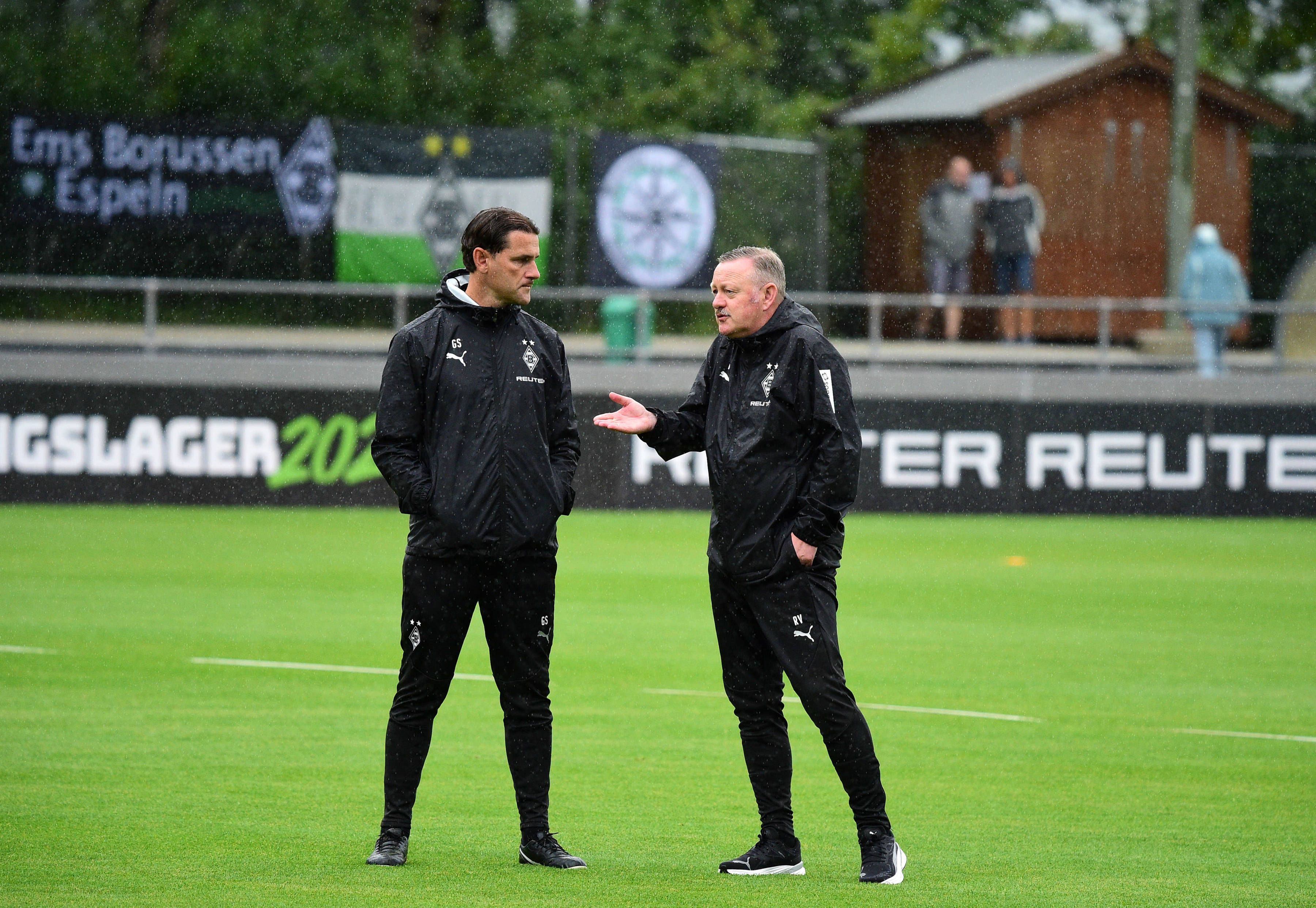 Gerardo Seoane und Roland Virkus unterhalten sich im Regen.