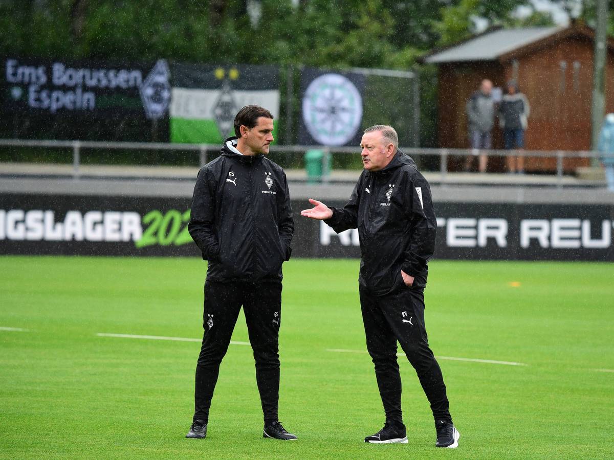 Gerardo Seoane und Roland Virkus unterhalten sich im Regen.