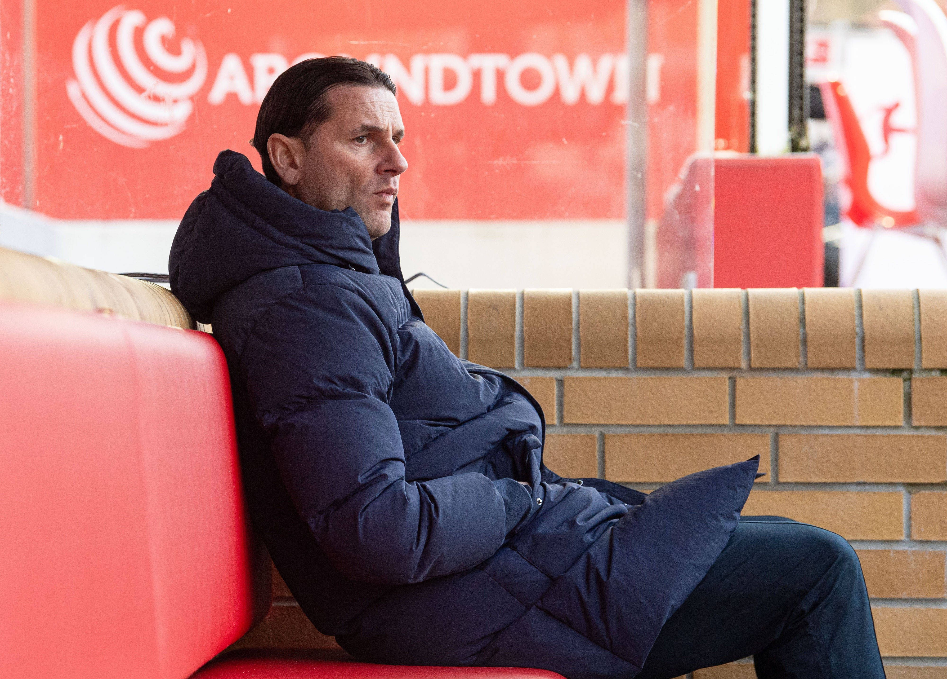 Borussia Mönchengladbachs Trainer Gerardo Seoane sitzt während des Bundesliga-Auswärtsspiels bei Union Berlin auf der Bank, hat die Hände in den Taschen vergraben und blickt skeptisch aufs Spielfeld.