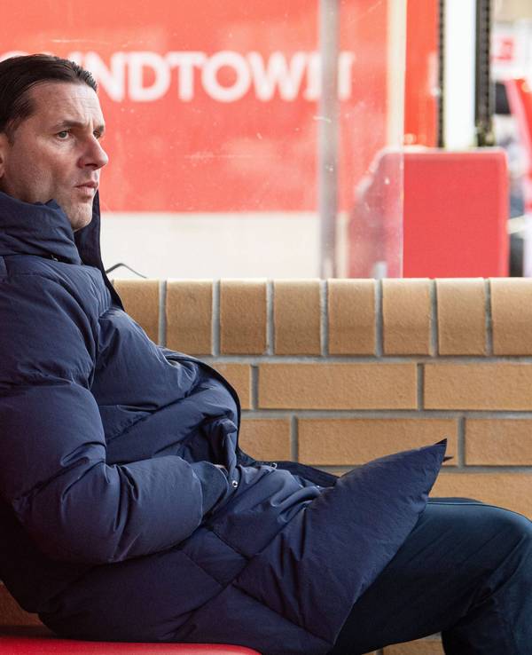 Borussia Mönchengladbachs Trainer Gerardo Seoane sitzt während des Bundesliga-Auswärtsspiels bei Union Berlin auf der Bank, hat die Hände in den Taschen vergraben und blickt skeptisch aufs Spielfeld.