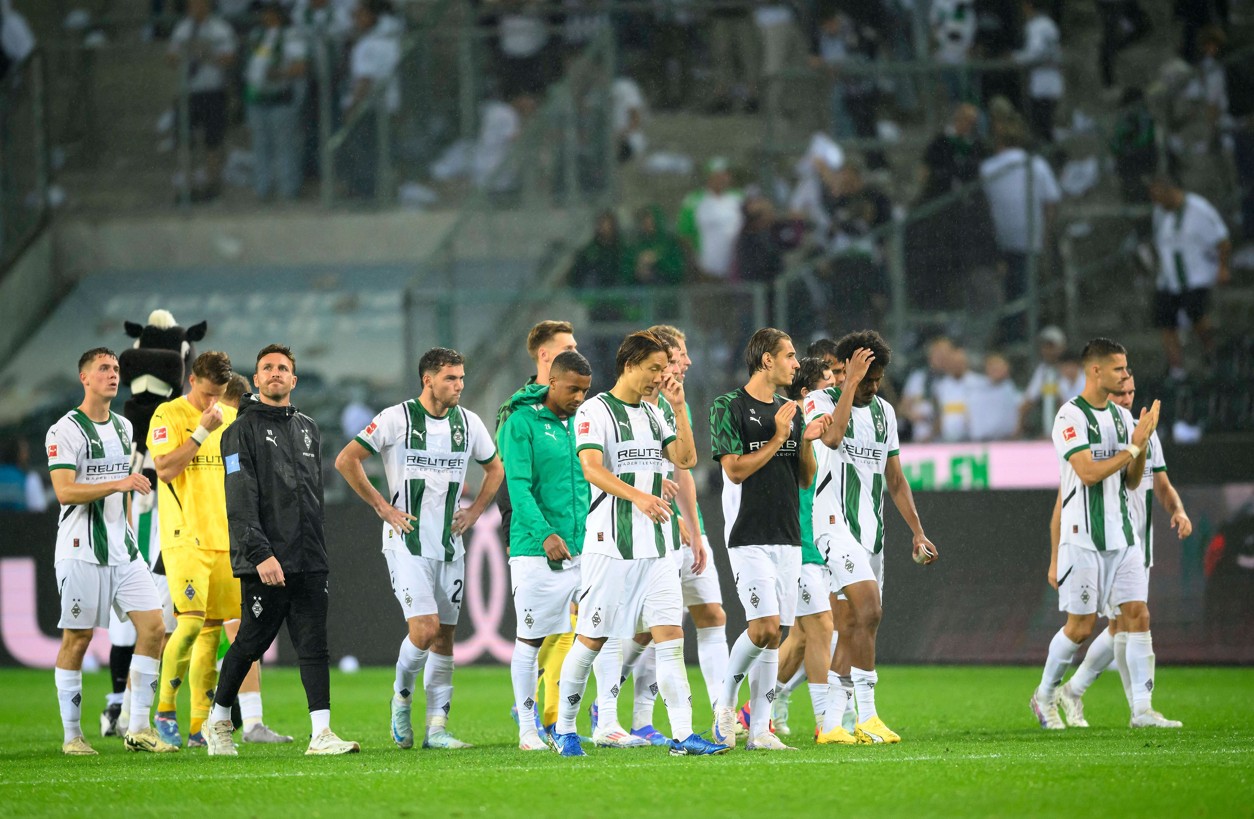 Spieler von Borussia Mönchengladbach schlendern frustriert vom Platz.