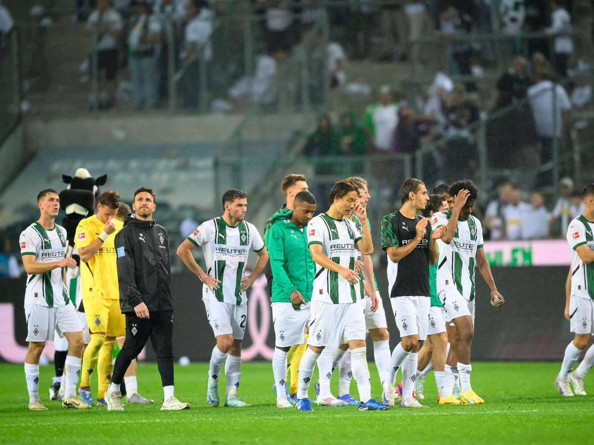 Spieler von Borussia Mönchengladbach schlendern frustriert vom Platz.