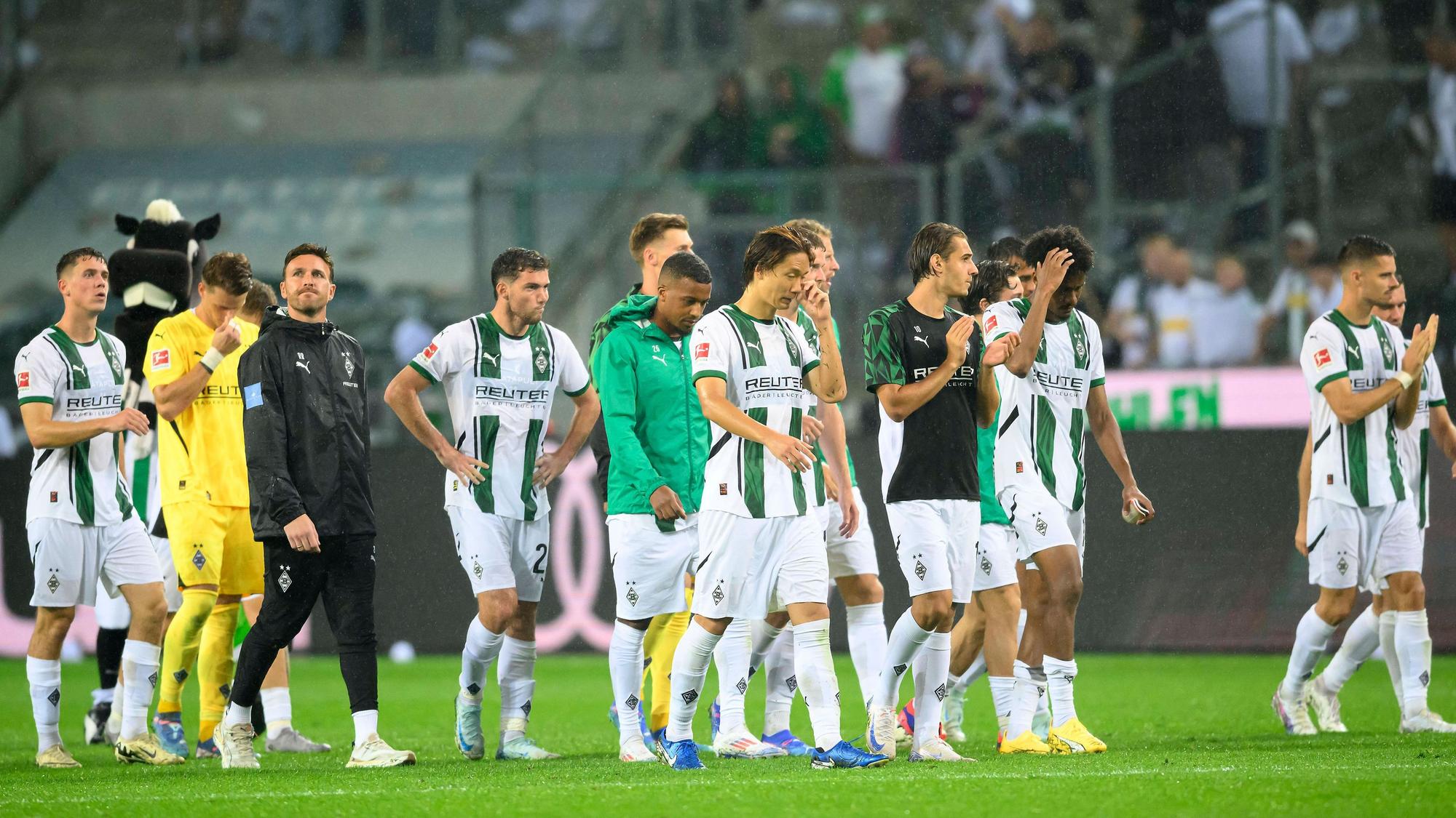 Spieler von Borussia Mönchengladbach schlendern frustriert vom Platz.