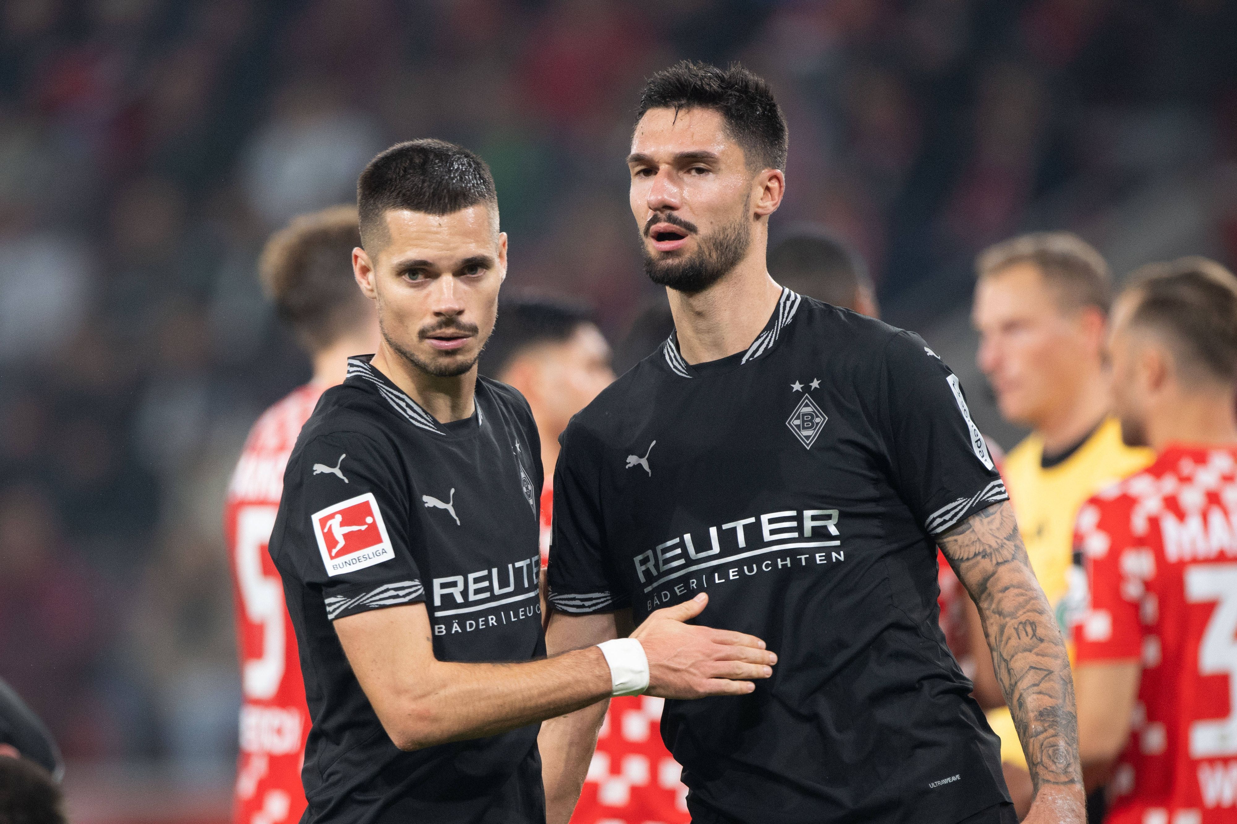 Die Gladbach-Profis Julian Weigl und Tim Kleindienst klatschen nach dem Bundesliga-Spiel beim 1. FSV Mainz 05 auf dem Platz ab.