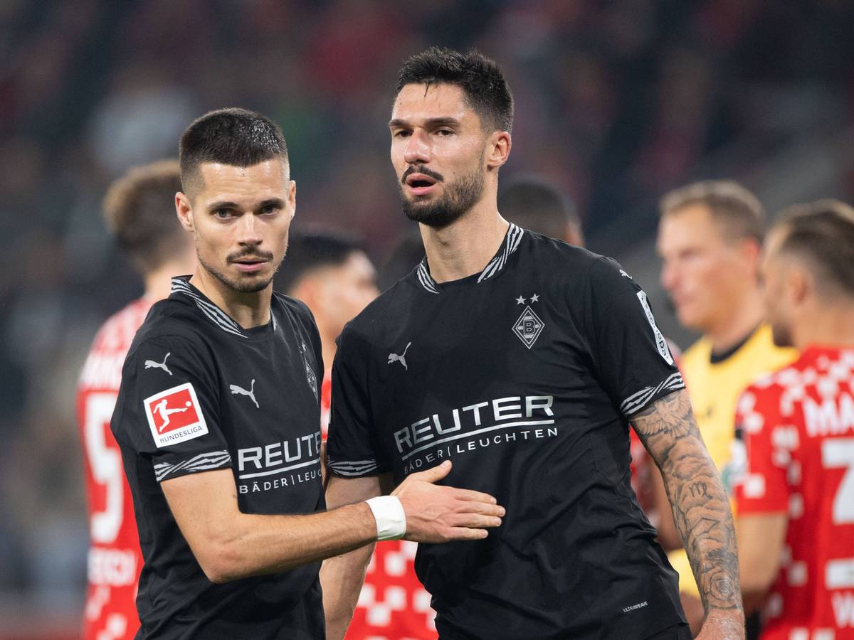 Die Gladbach-Profis Julian Weigl und Tim Kleindienst klatschen nach dem Bundesliga-Spiel beim 1. FSV Mainz 05 auf dem Platz ab.