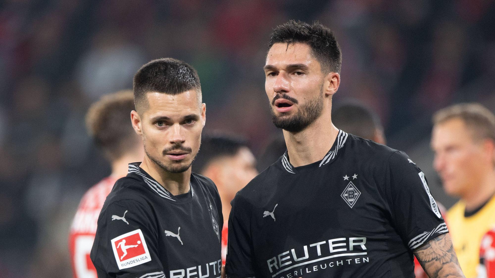 Die Gladbach-Profis Julian Weigl und Tim Kleindienst klatschen nach dem Bundesliga-Spiel beim 1. FSV Mainz 05 auf dem Platz ab.