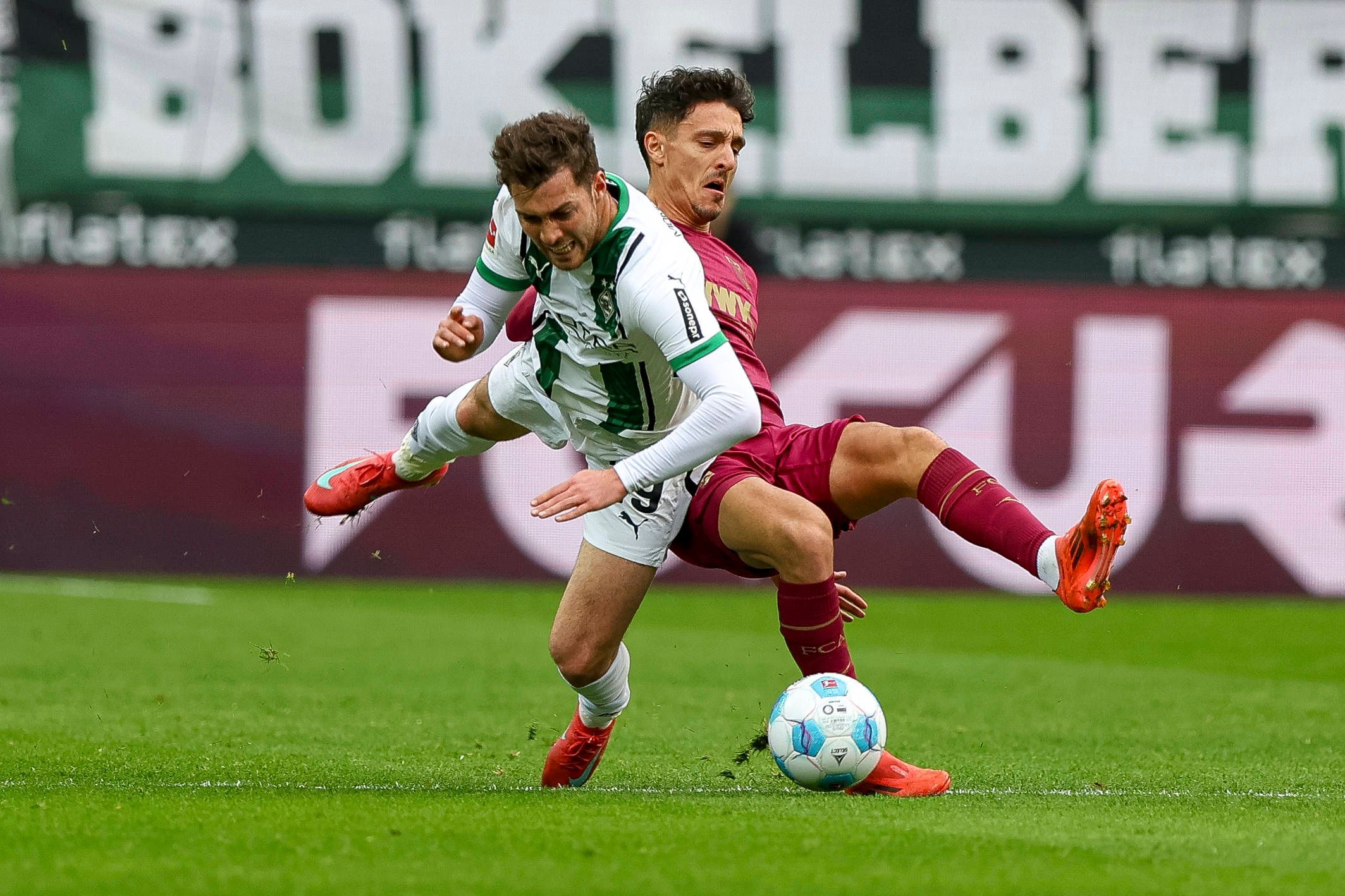 Borussia Mönchengladbachs Joe Scally und Augsburgs Dimitrios Giannoulis kämpfen um den Ball.