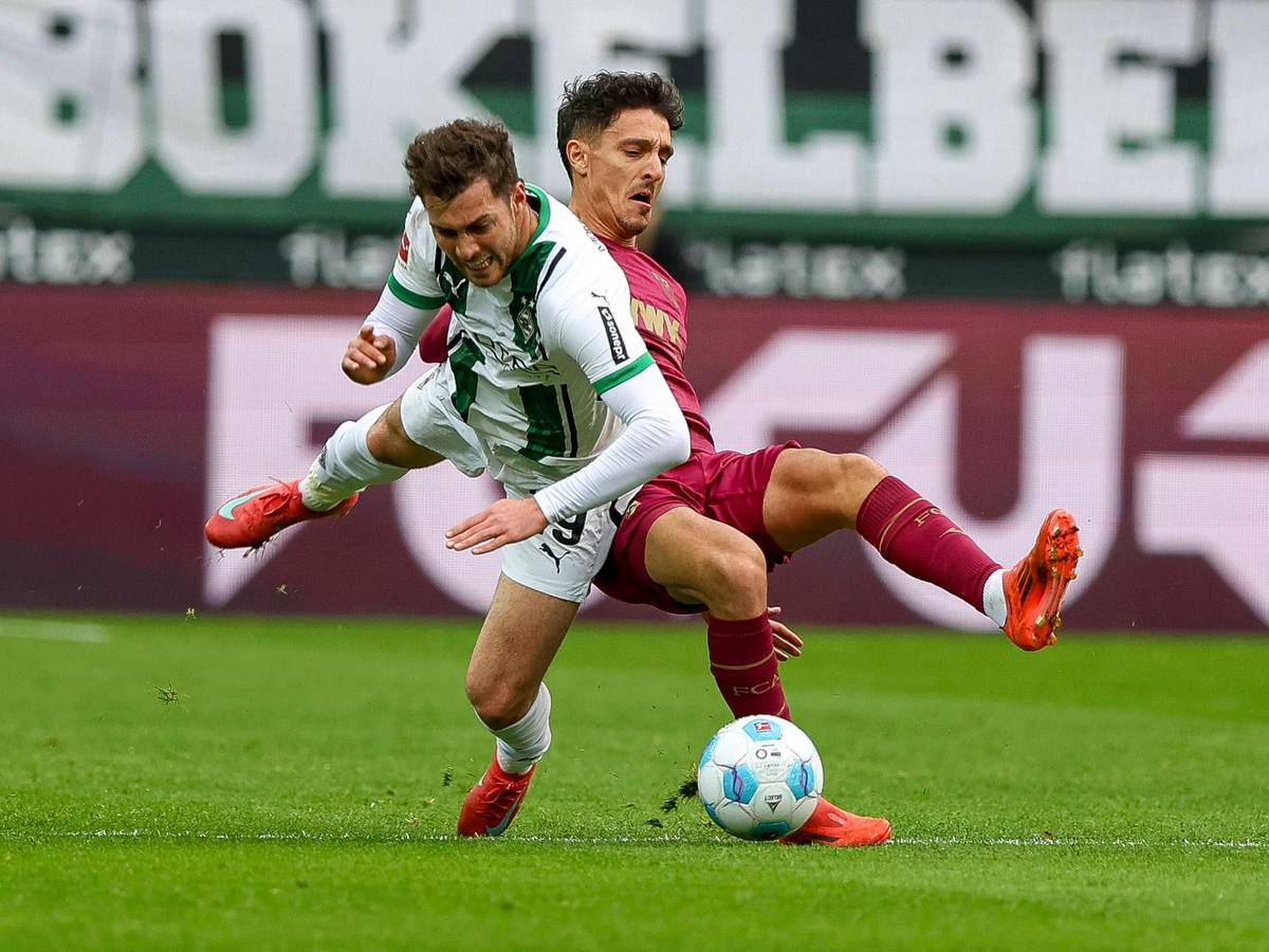 Borussia Mönchengladbachs Joe Scally und Augsburgs Dimitrios Giannoulis kämpfen um den Ball.