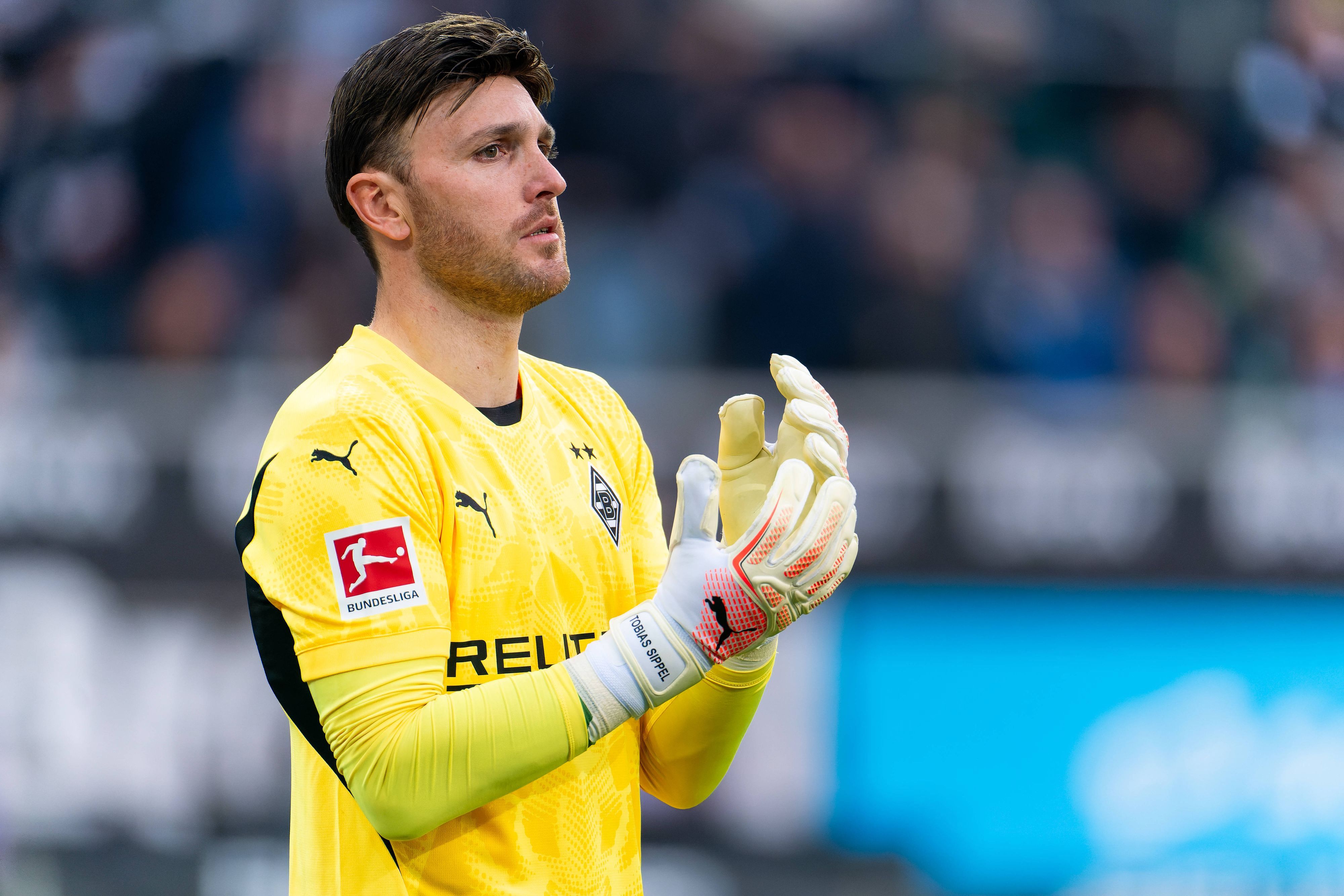 Borussia Mönchengladbachs Torwart Tobias Sippel steht im Bundesliga-Spiel gegen den FC Augsburg im Tor und richtet sich die Handschuhe.